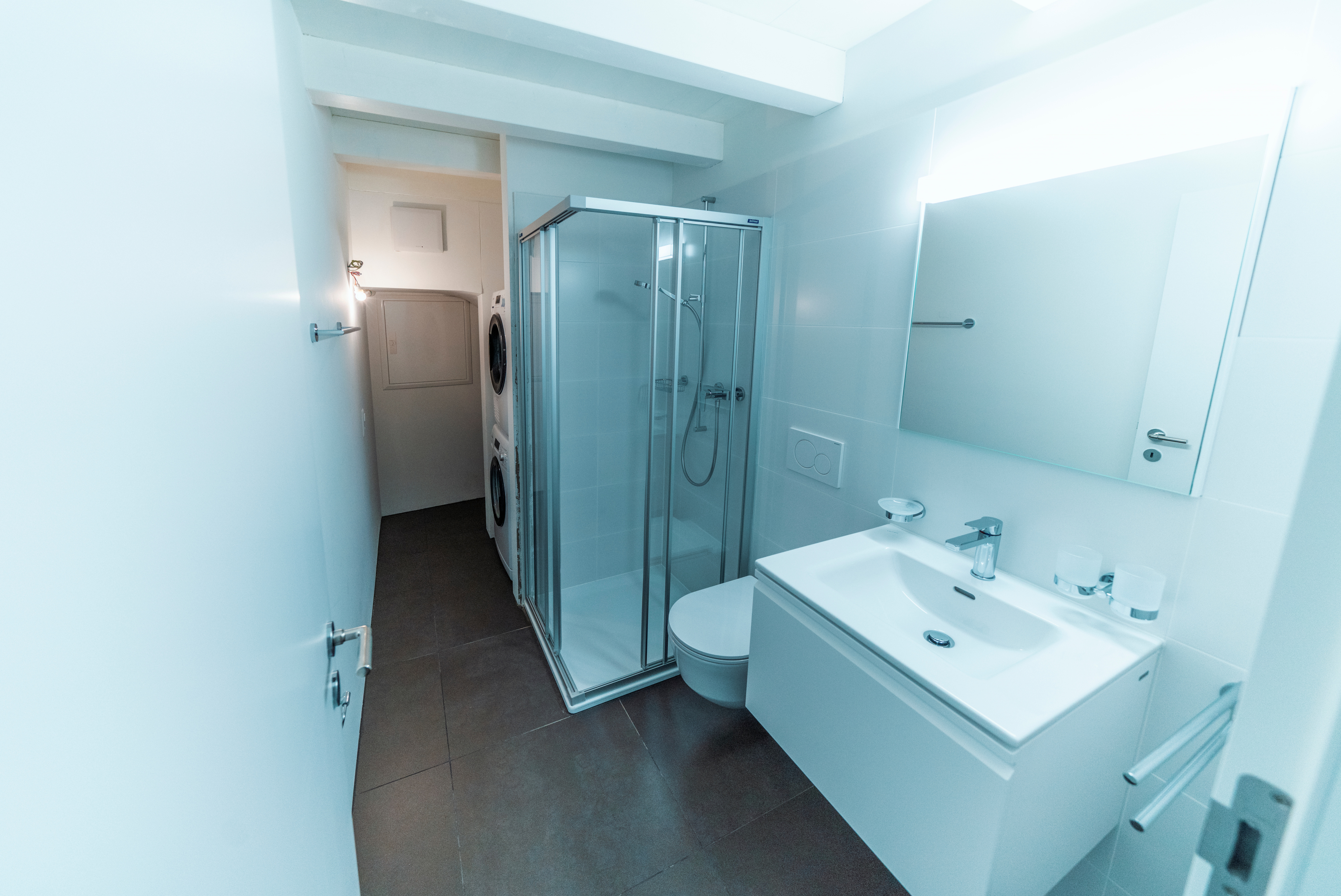 Schmales, modernes Badezimmer mit Dusche und Waschtisch