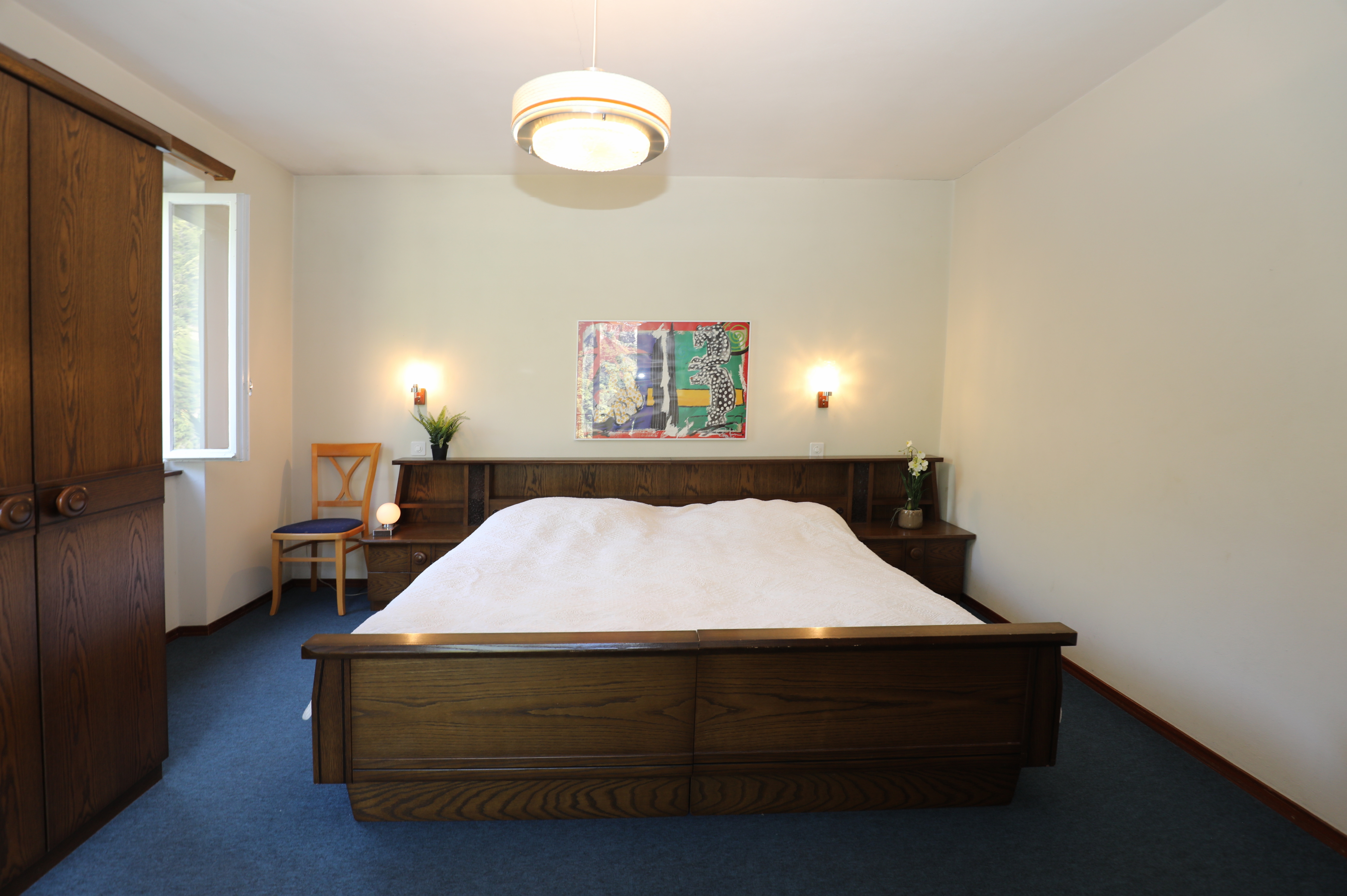 Schlafzimmer mit dunklen Holzmöbeln