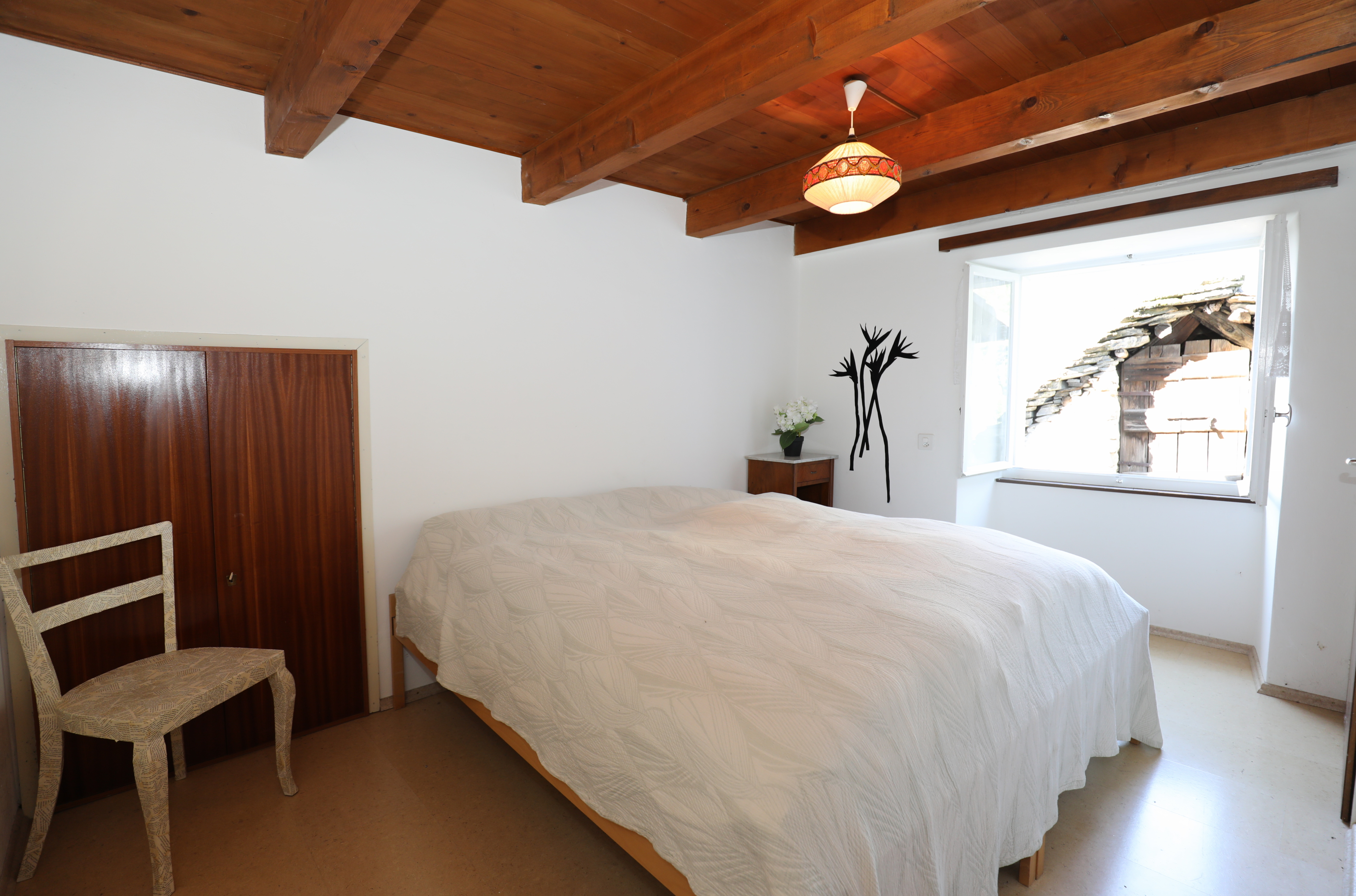 Schlafzimmer mit Holzbalkendecke