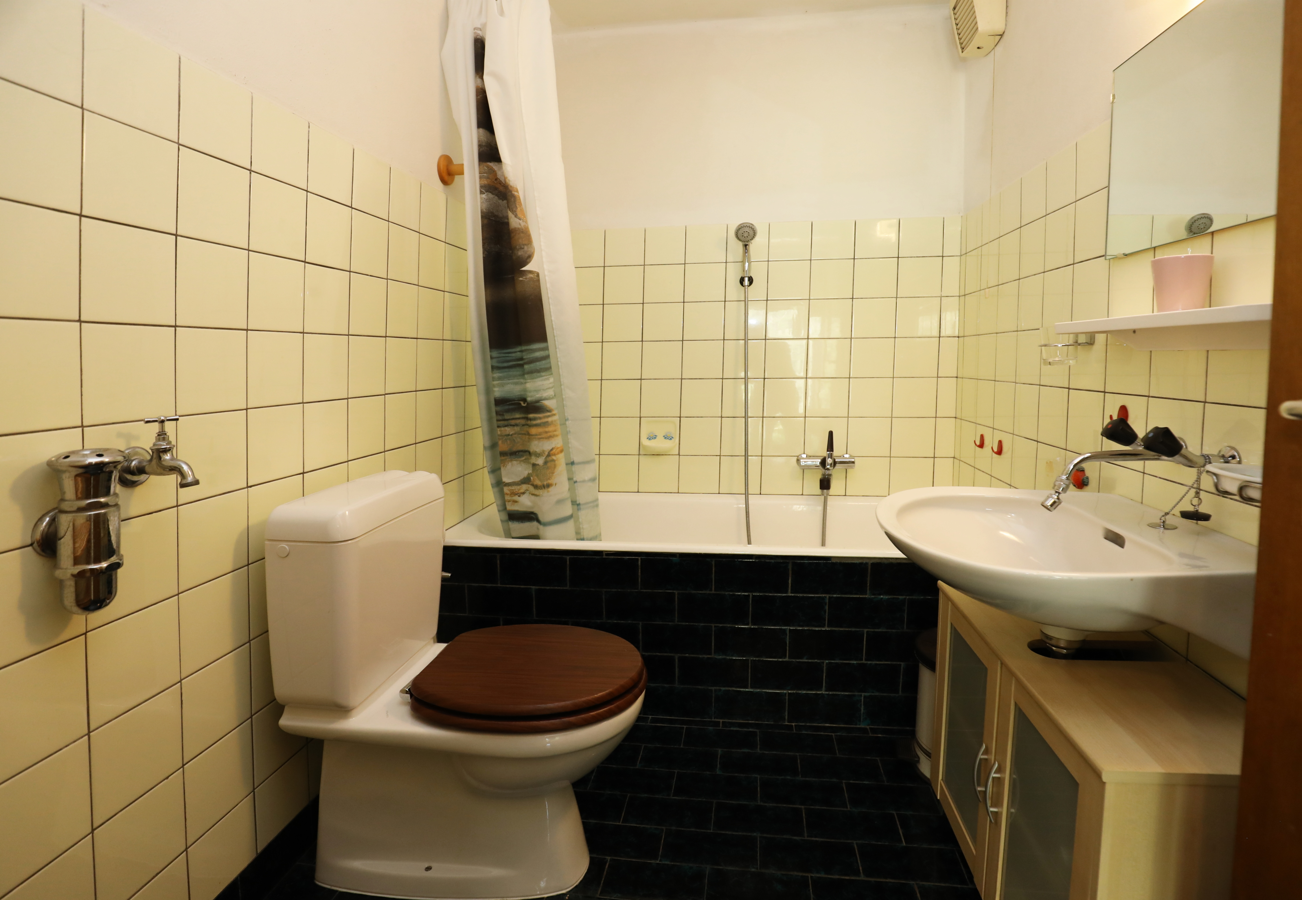 Kleines Badezimmer mit Badewanne, WC und Waschbecken