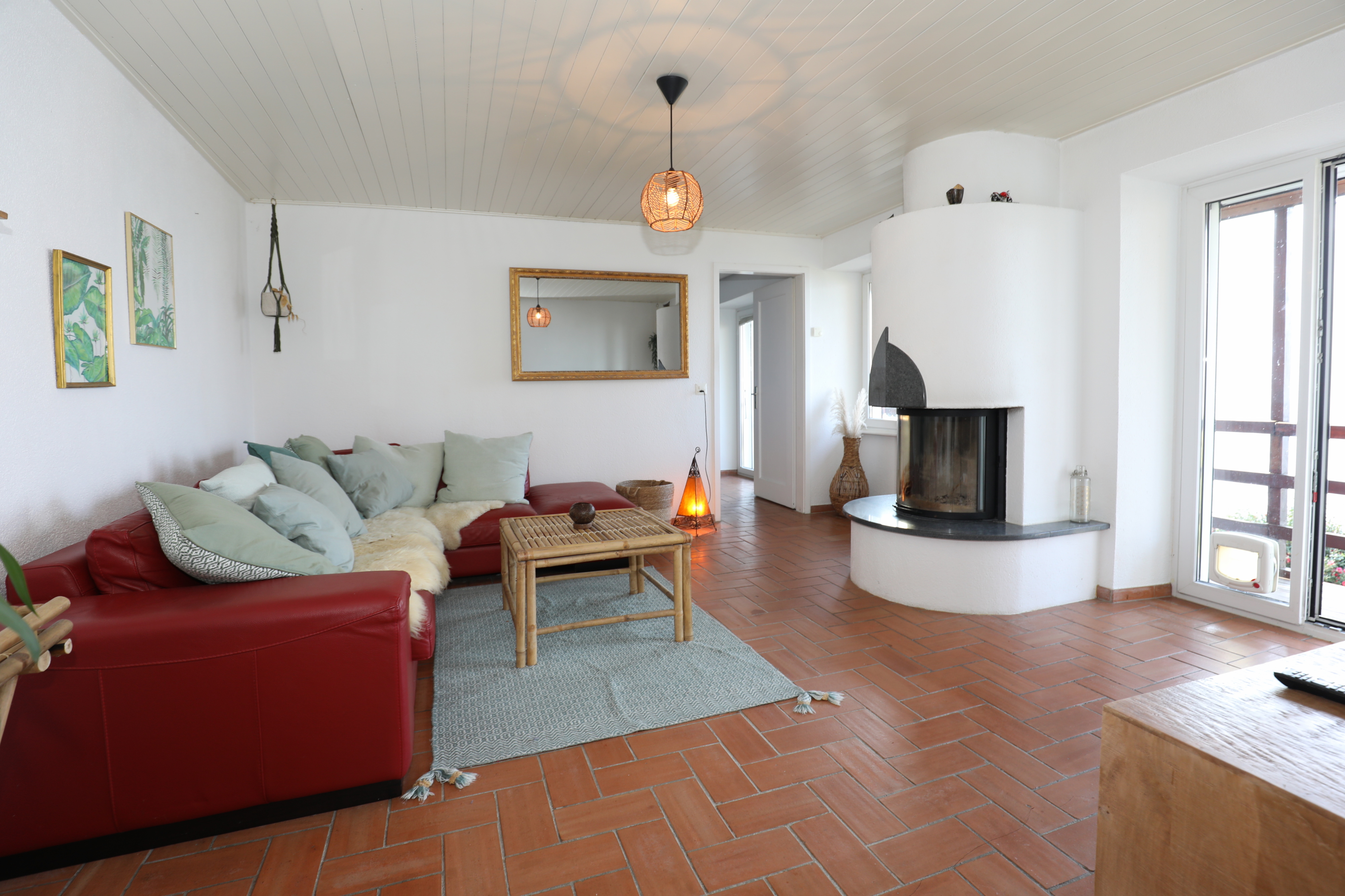 Gemütliches Wohnzimmer mit Kamin und rotem Sofa