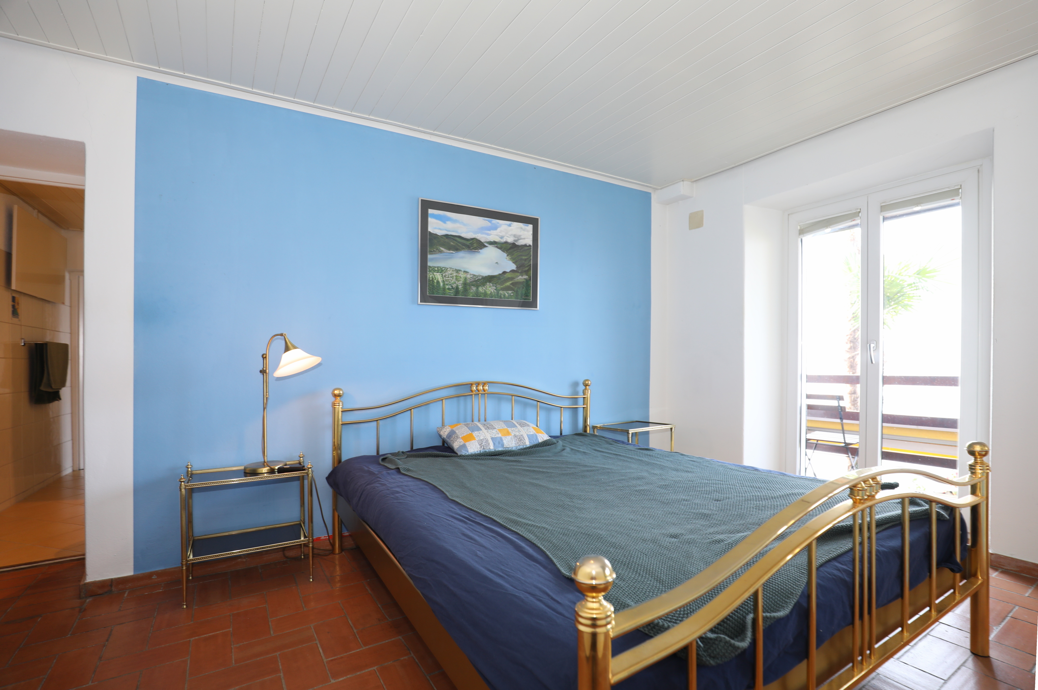 Schlafzimmer mit blauem Akzent und goldfarbenem Bettgestell