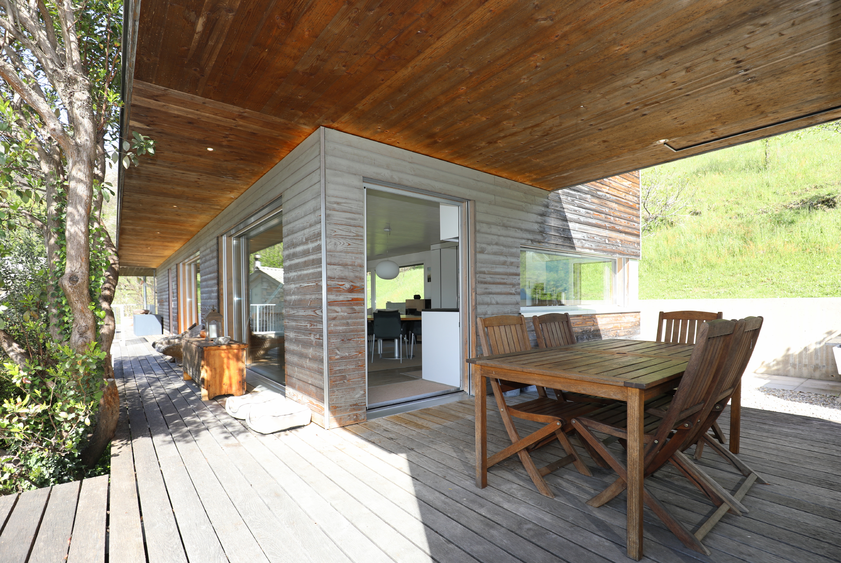 Überdachte Holzterrasse mit Gartenblick