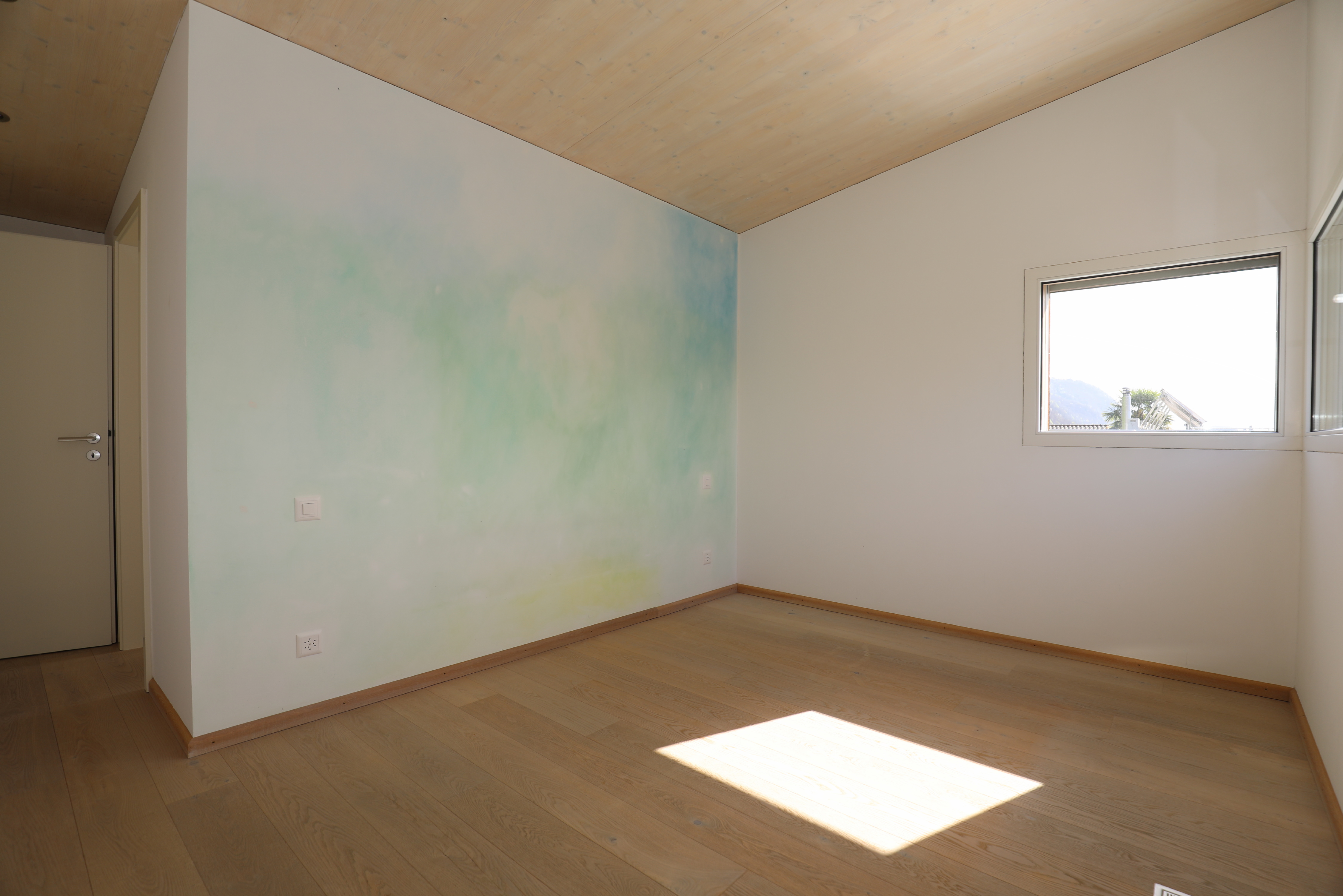 Leerer Raum mit Dachschräge und Tageslicht