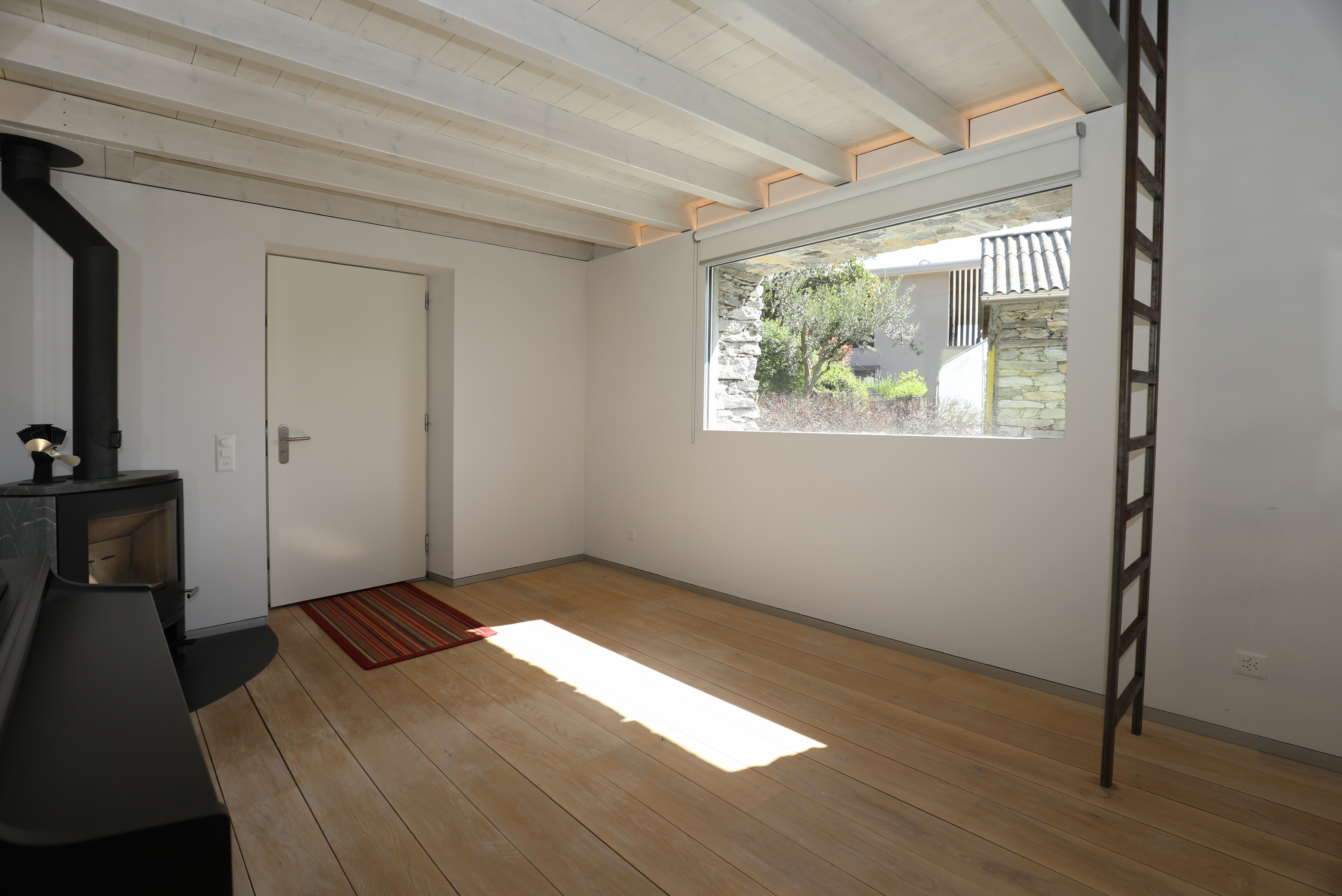Heller Raum mit Holzdecke und Ofen