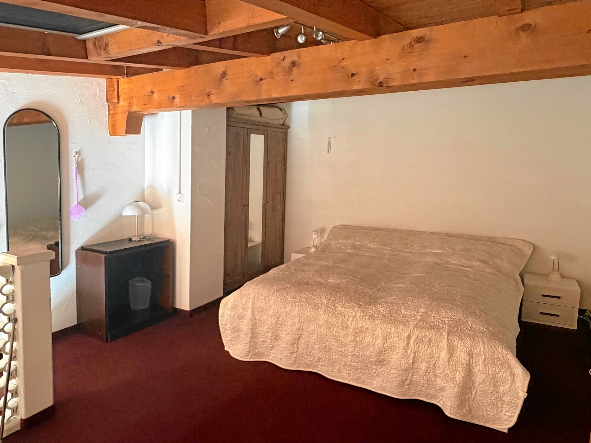 Gemütliches Schlafzimmer mit sichtbaren Holzbalken