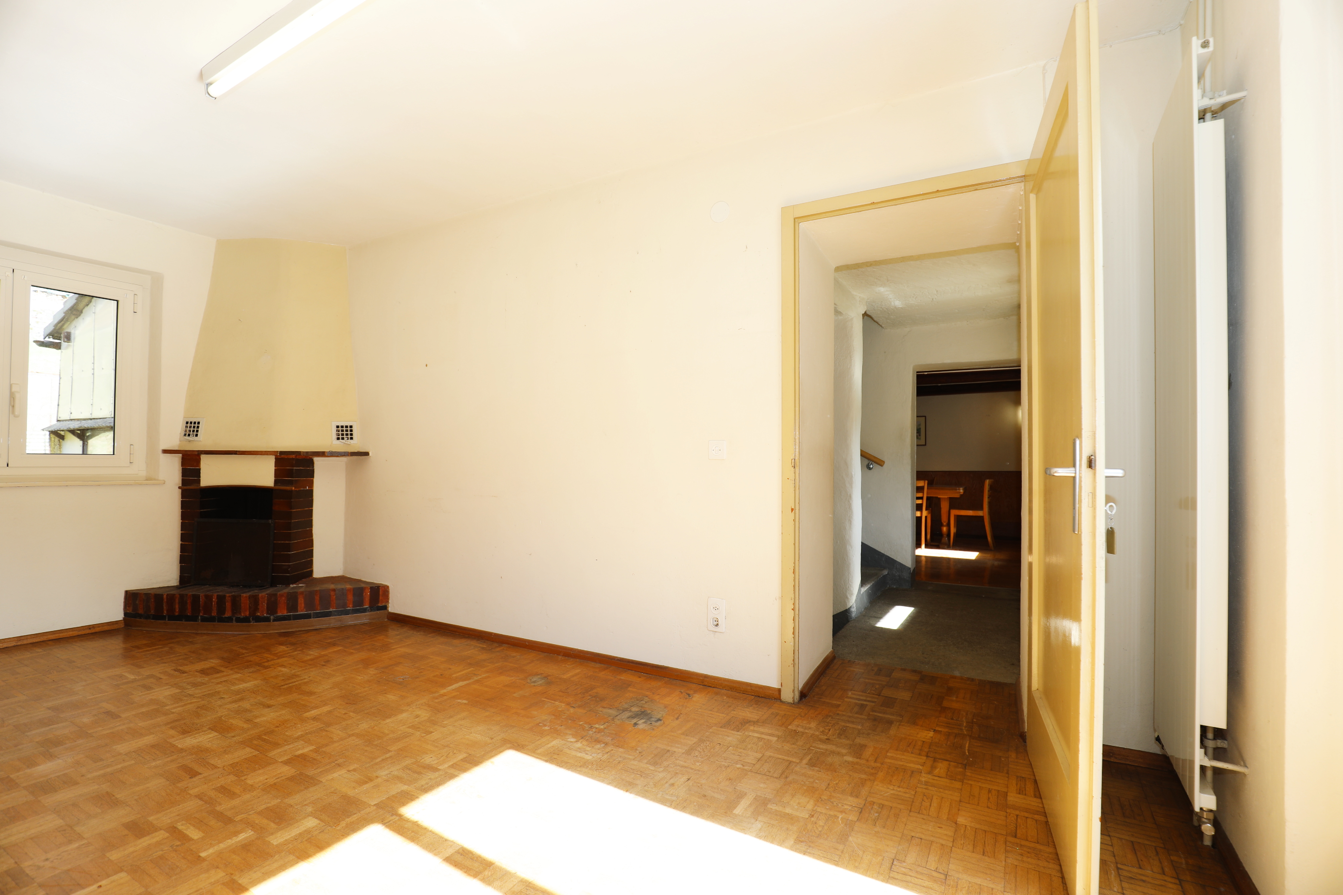 Wohnzimmer mit Kamin und Parkettboden