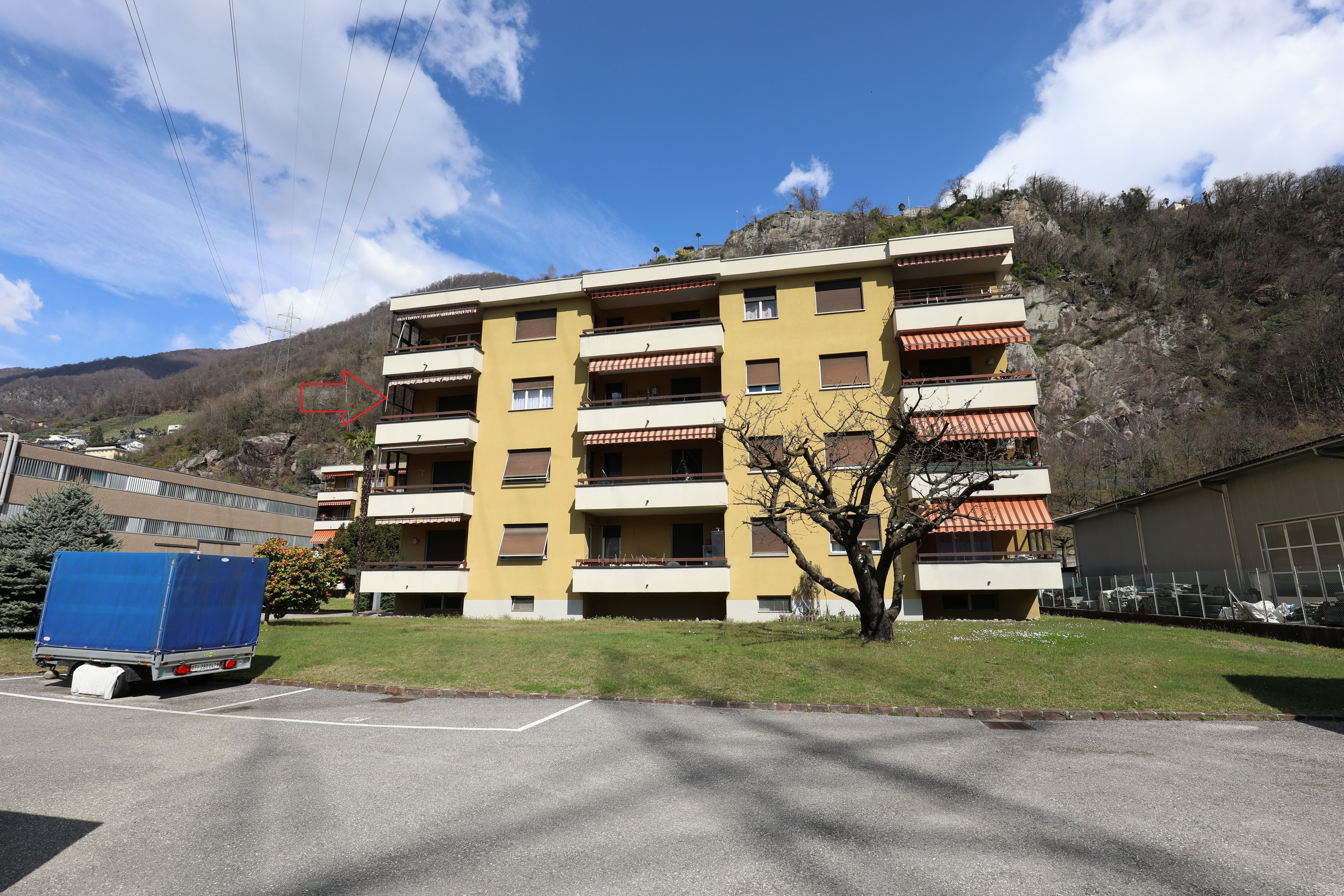 Wohnhaus mit Balkonen vor Bergkulisse