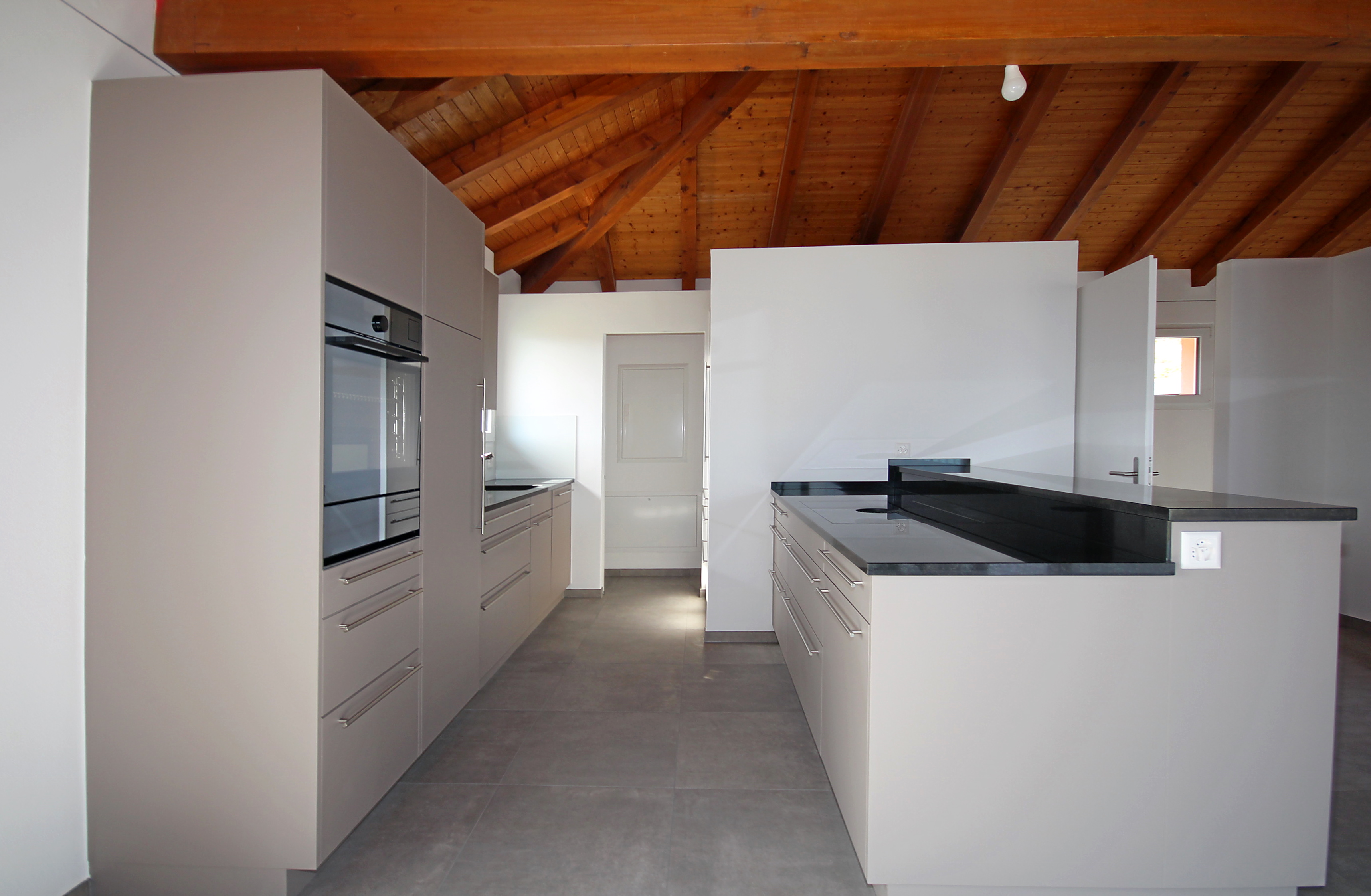 Moderne Küche mit Holzdach und Kochinsel