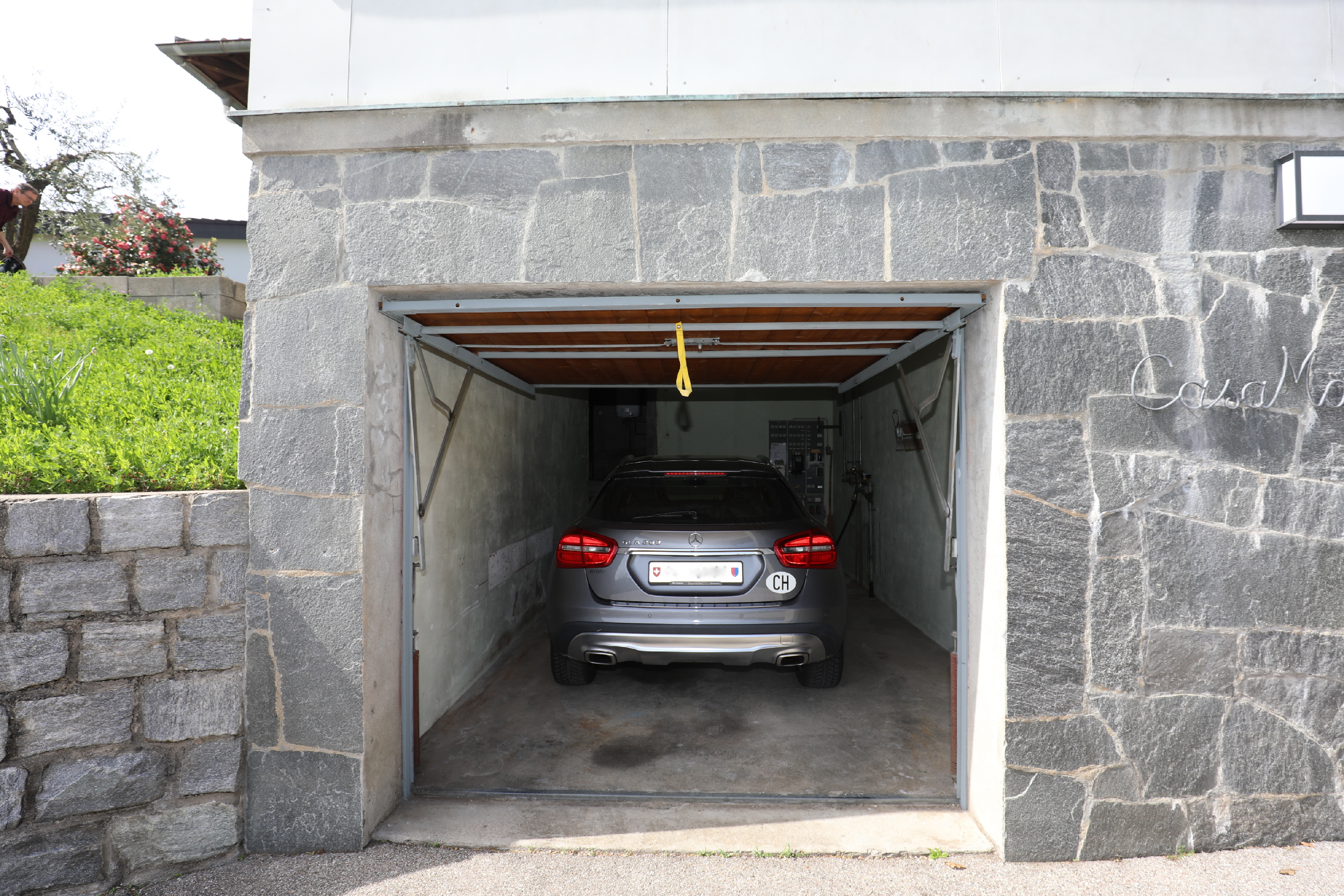 Garage mit Fahrzeug in Natursteinfassade