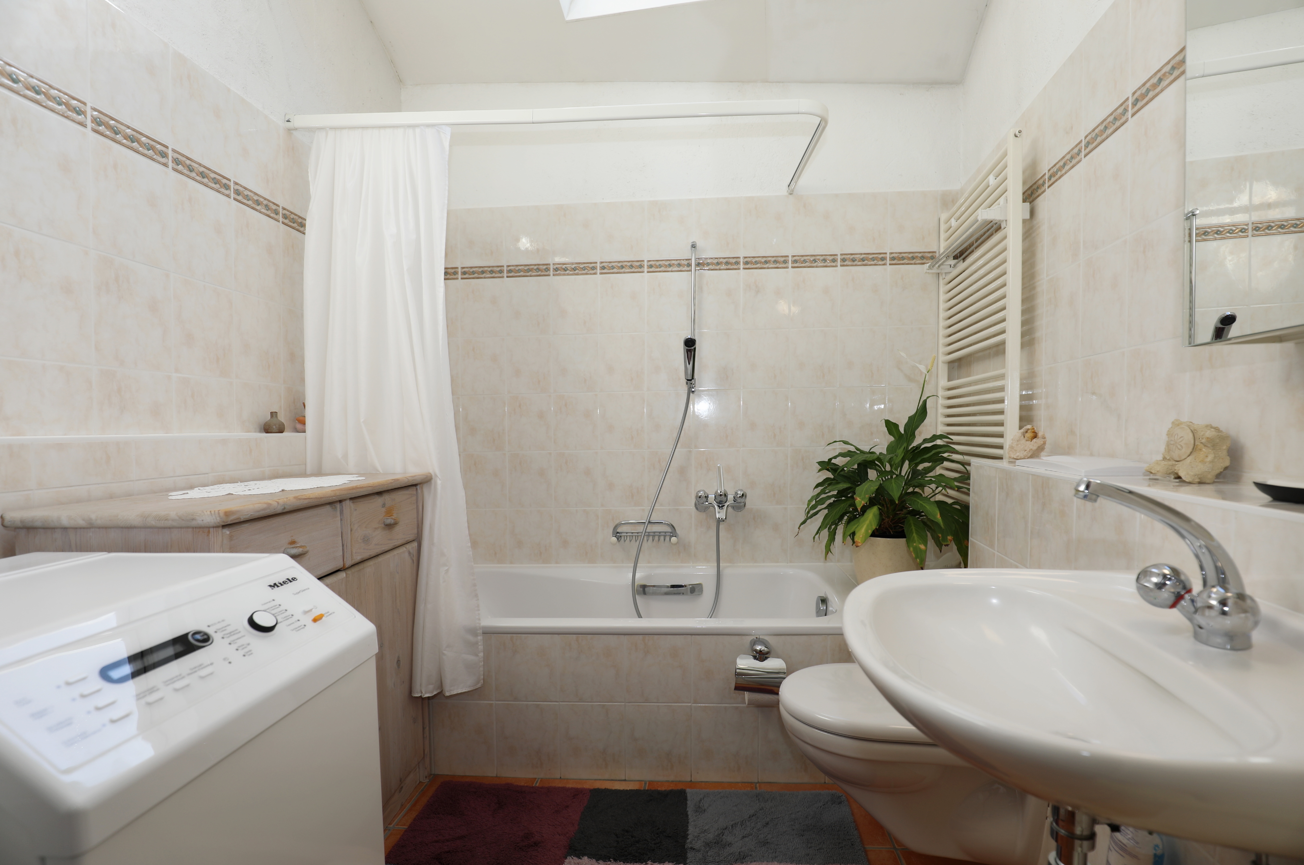 Badezimmer mit Wanne und Waschplatz