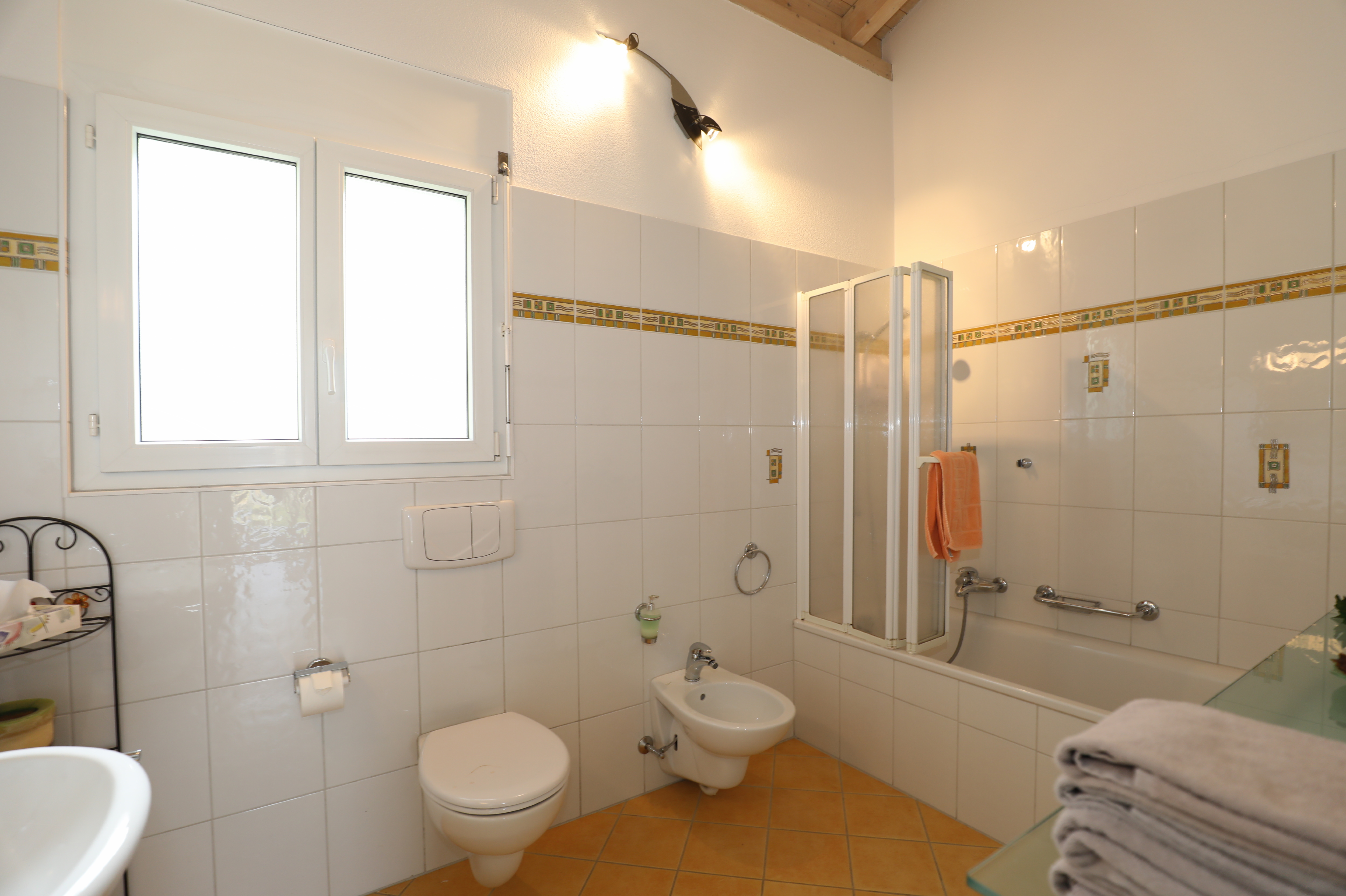 Helles Badezimmer mit Badewanne und WC