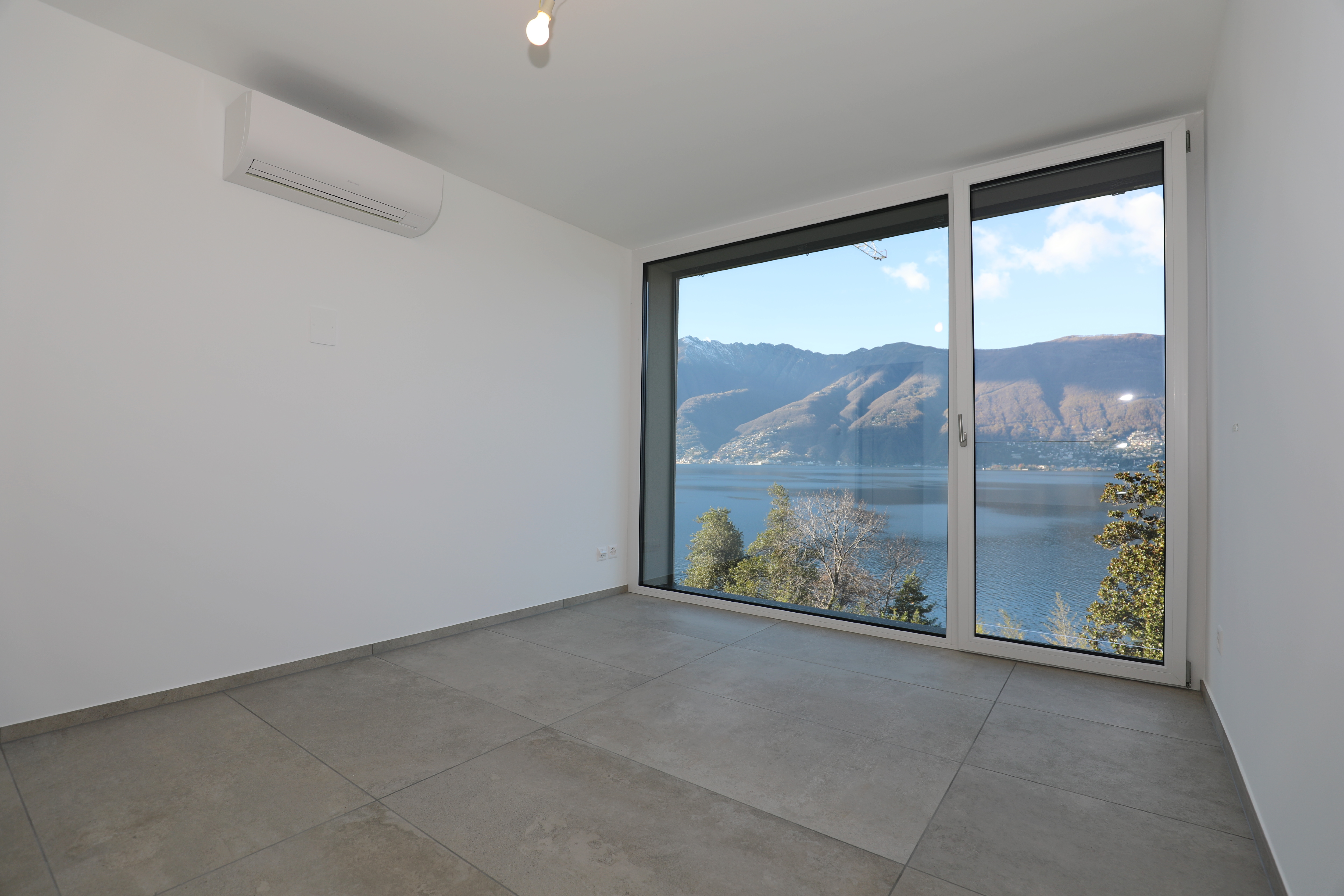 Leerer Raum mit Panoramafenster und Seeblick