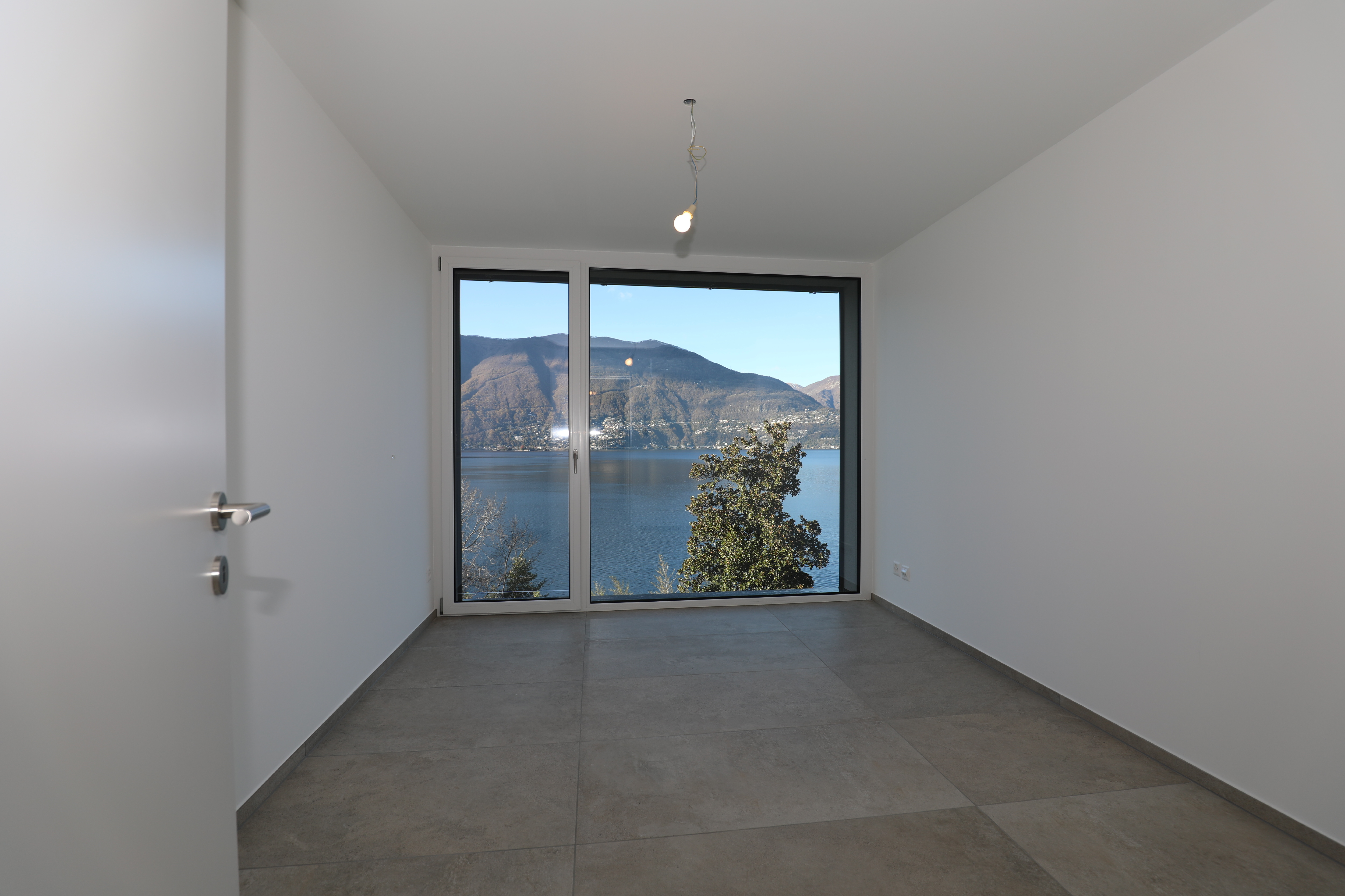 Leerer Raum mit Panoramafenster und Seeblick