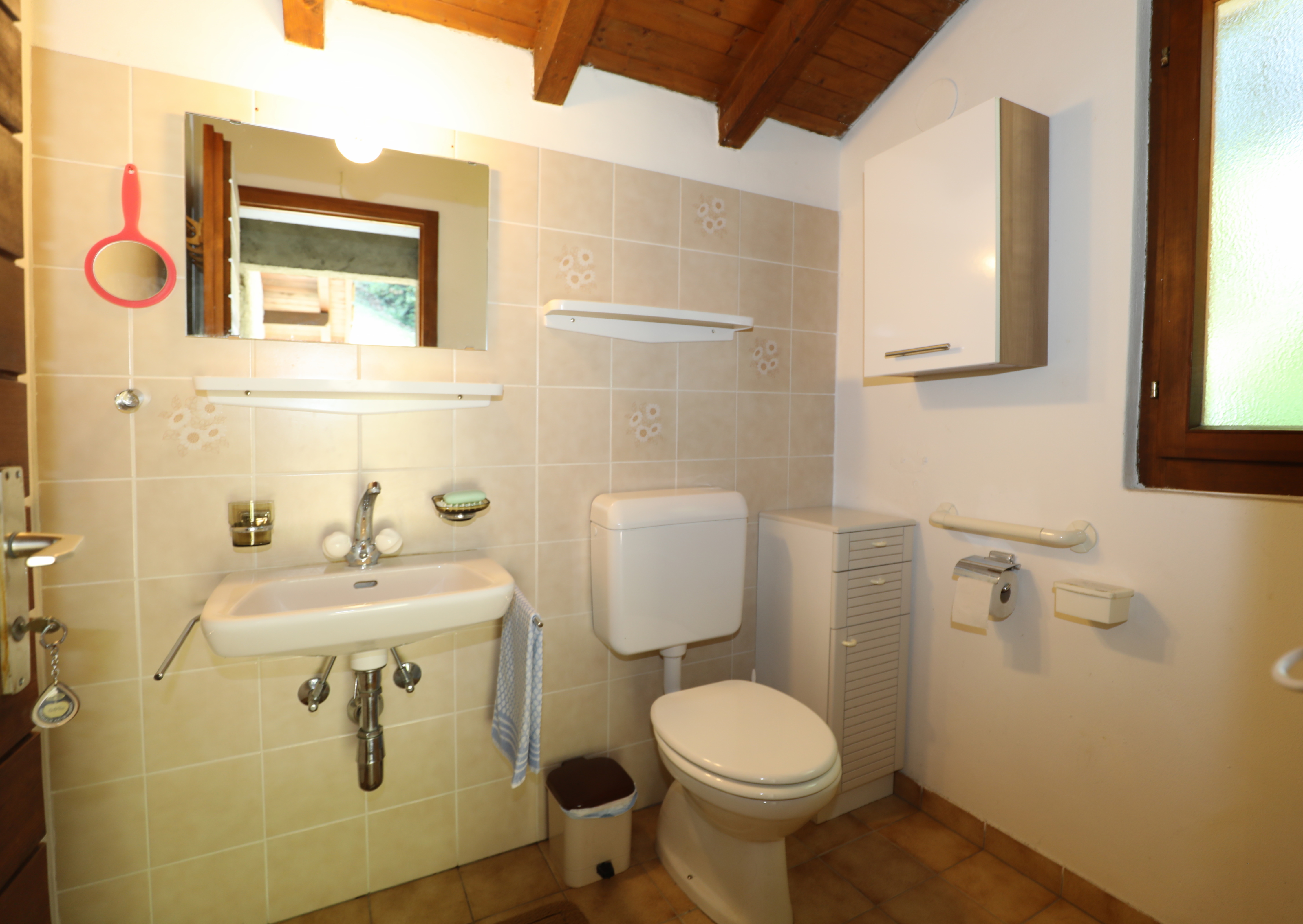 Kleines Badezimmer mit Holzdecke und Dachfenster