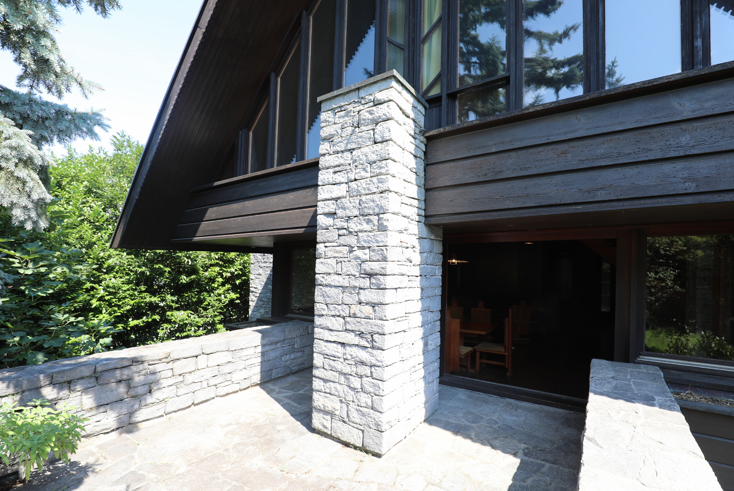 Außenansicht einer rustikalen Architektur mit Naturstein und dunklem Holz