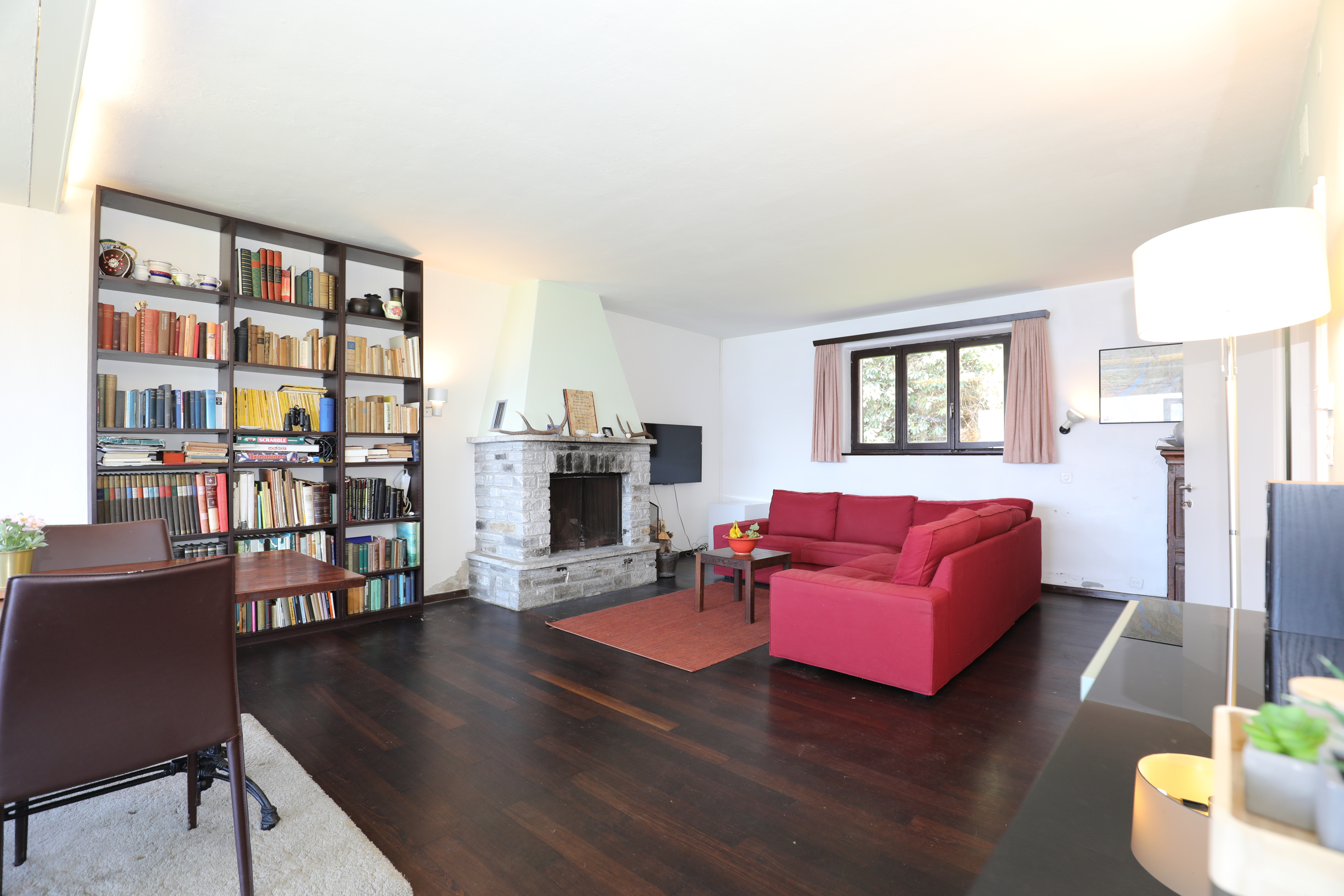 Wohnzimmer mit Kamin und Bücherregal