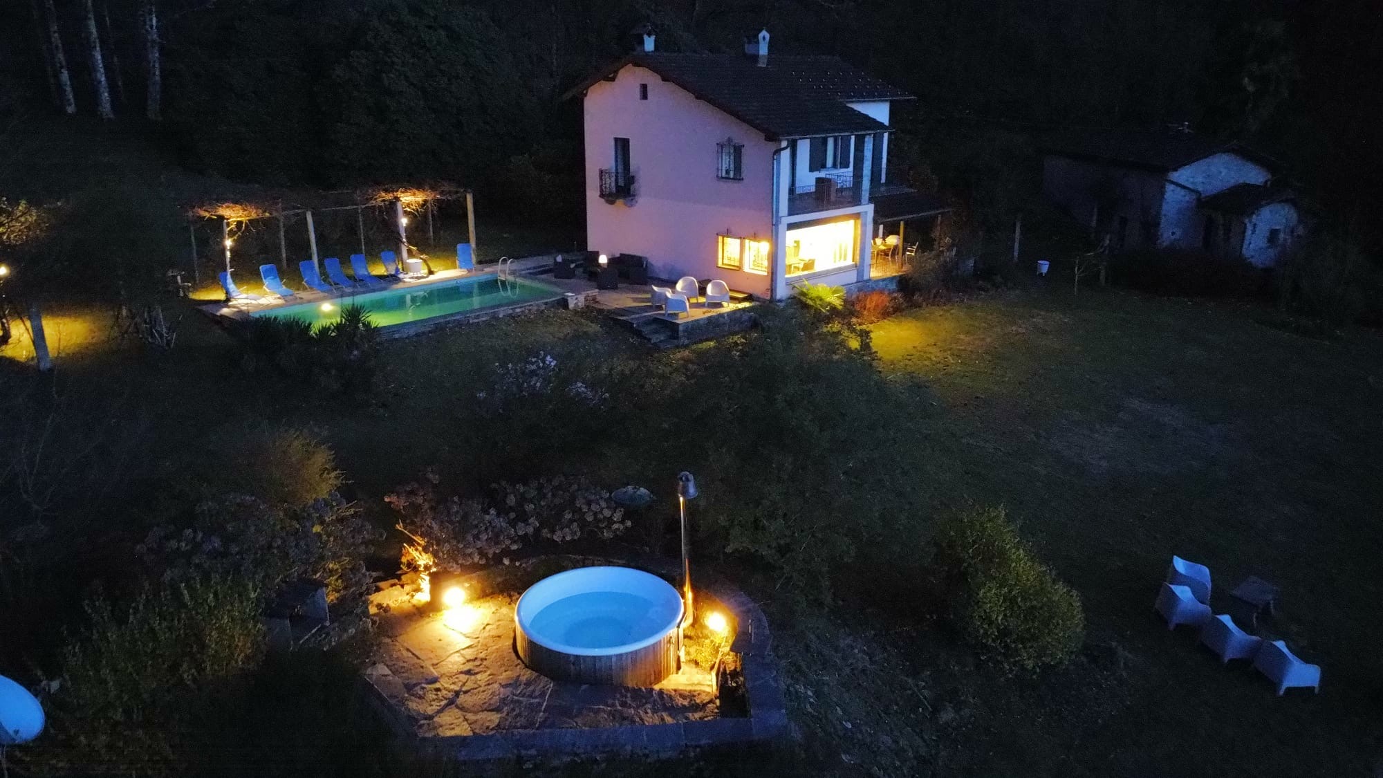 Außenansicht eines Hauses mit Pool und Whirlpool bei Nacht