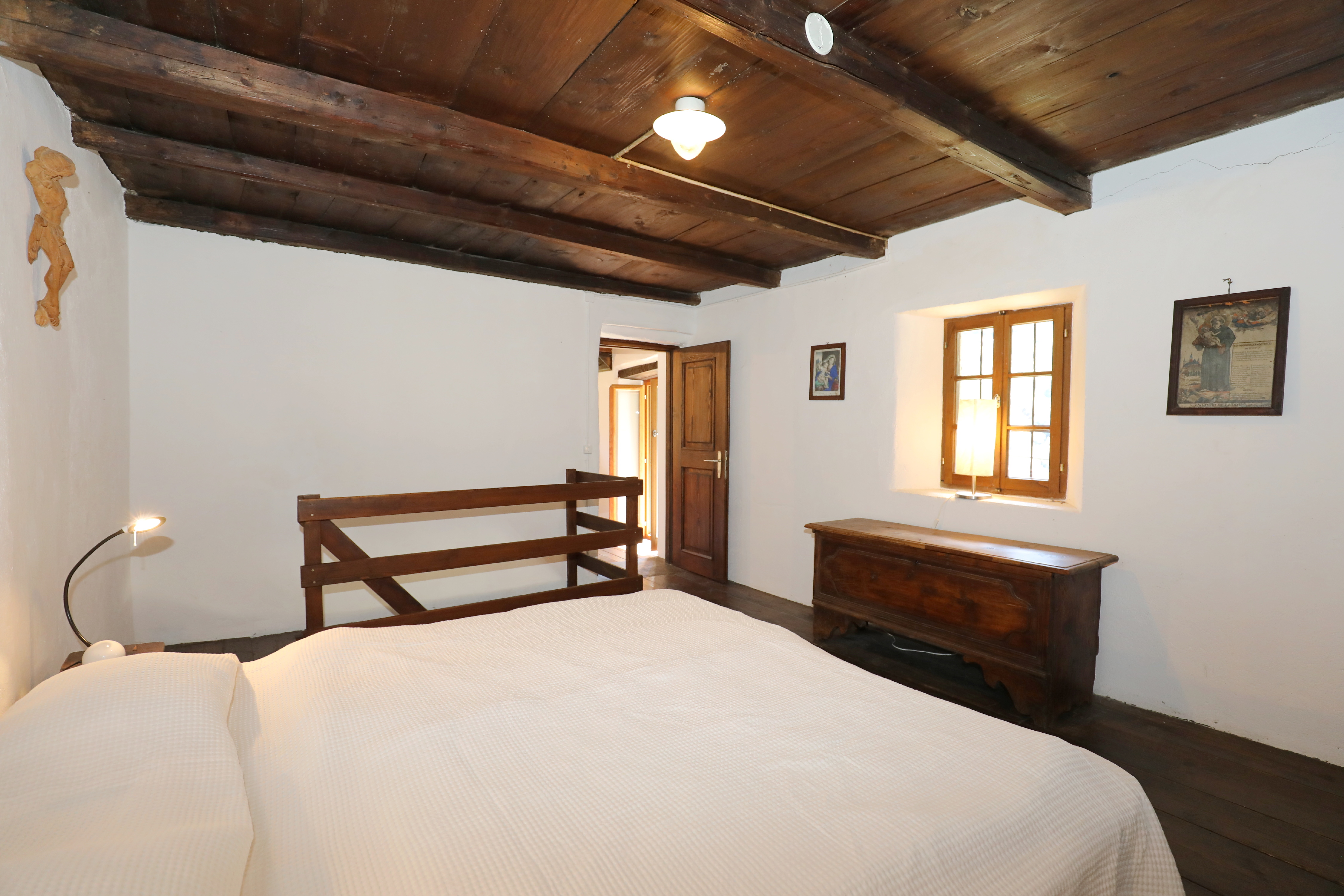 Rustikales Schlafzimmer mit Holzbalkendecke