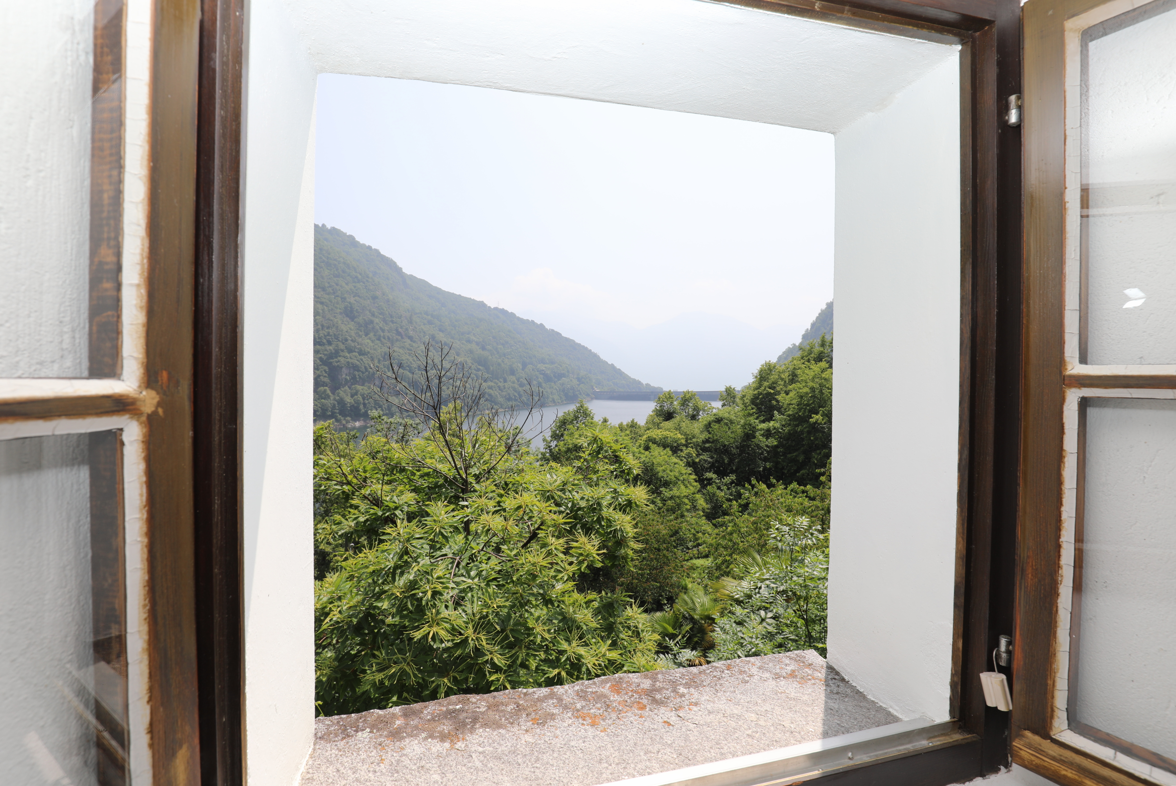 Fensterblick auf See und grüne Berge