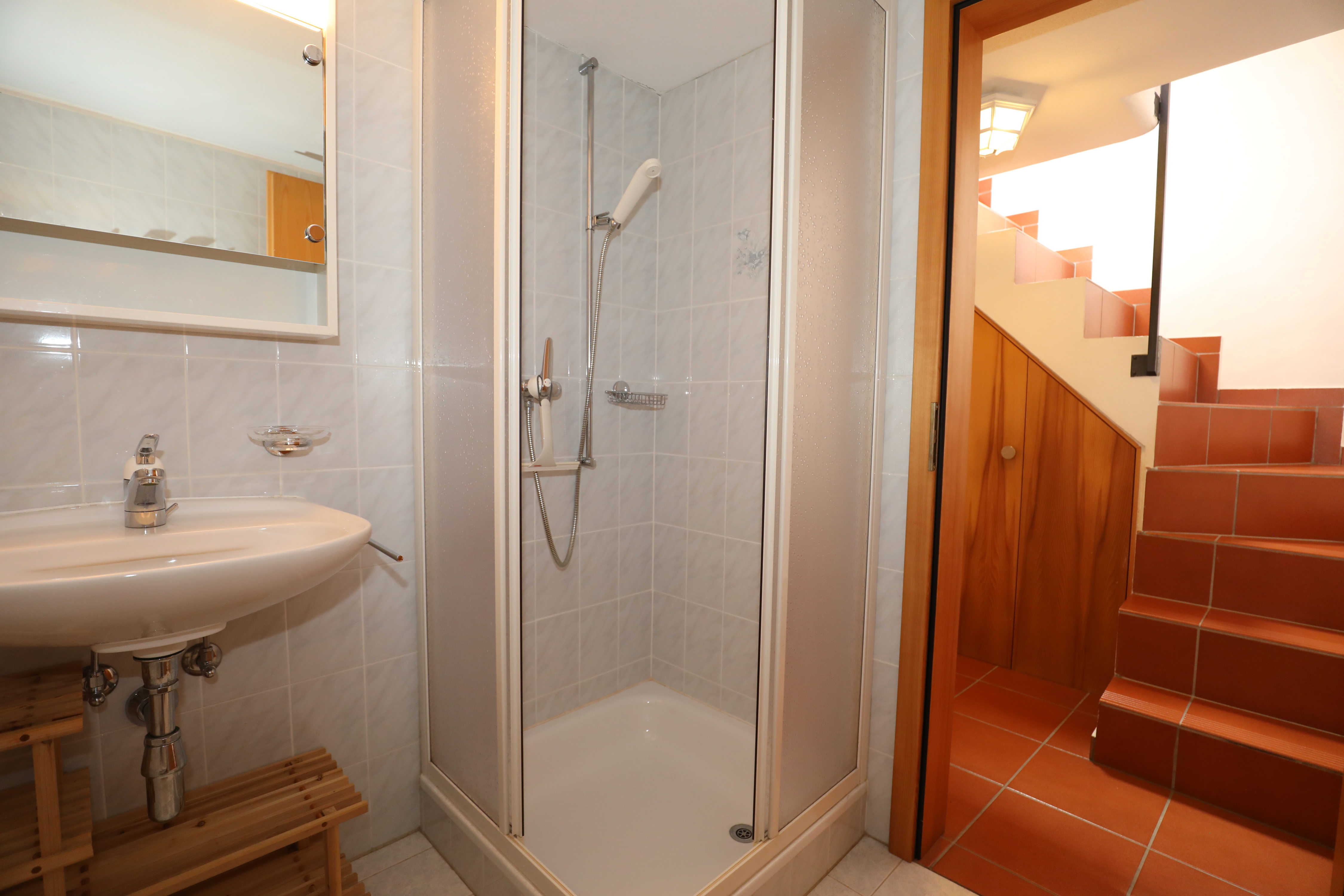 Badezimmer mit Dusche und Treppenaufgang