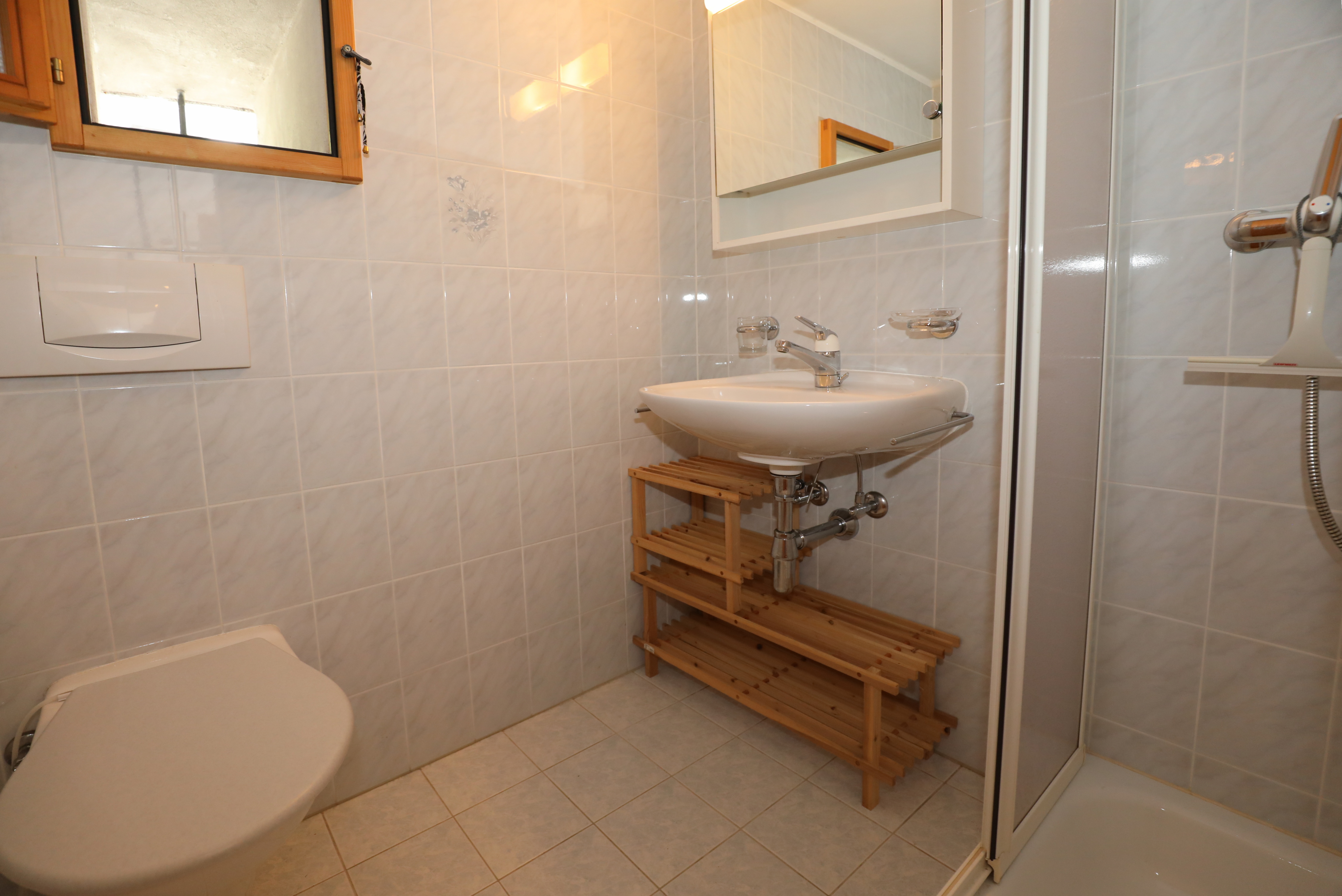 Kleines helles Badezimmer mit Dusche und Wand-WC