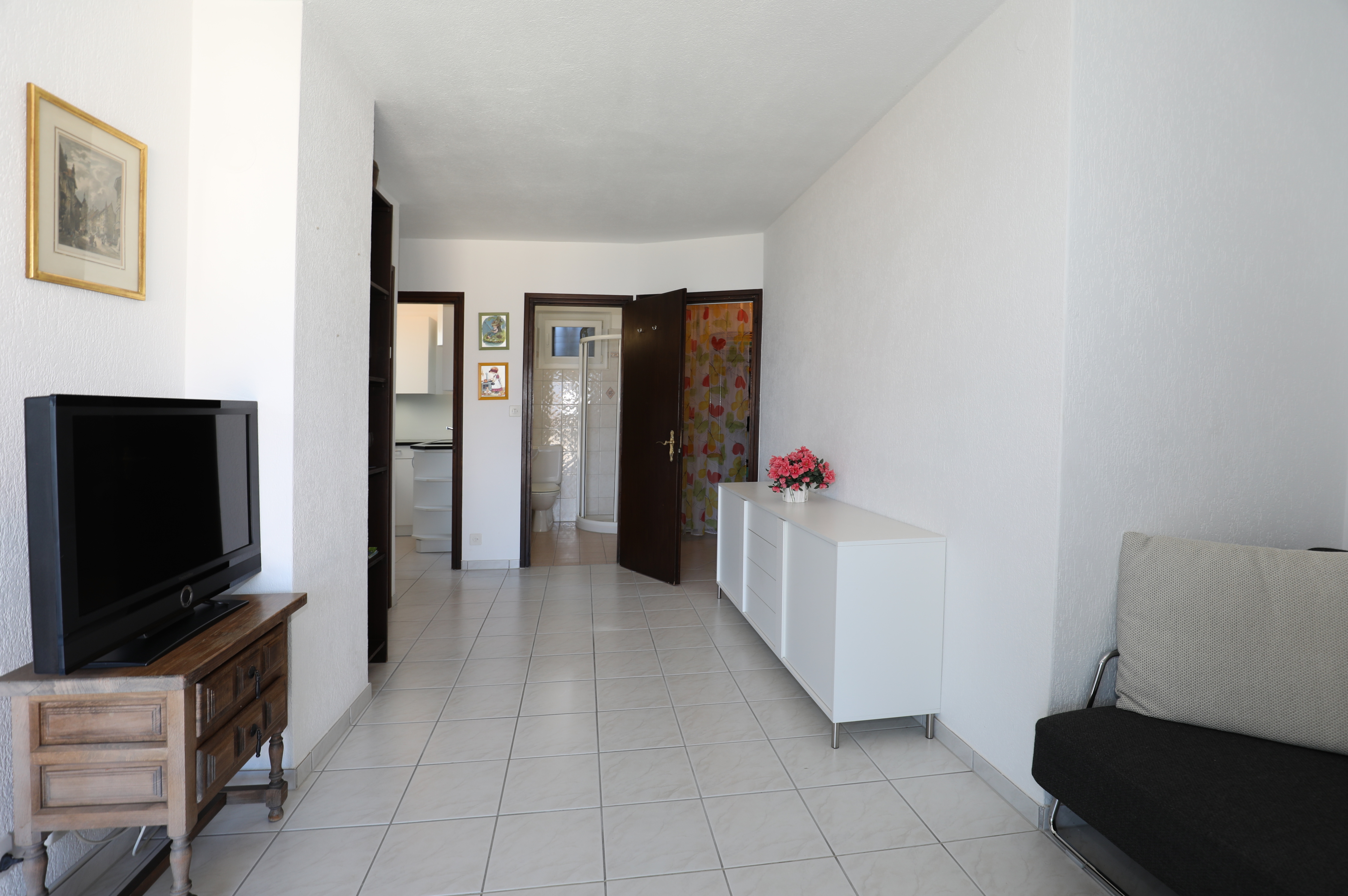 Wohnzimmer mit Blick in Bad und Küche