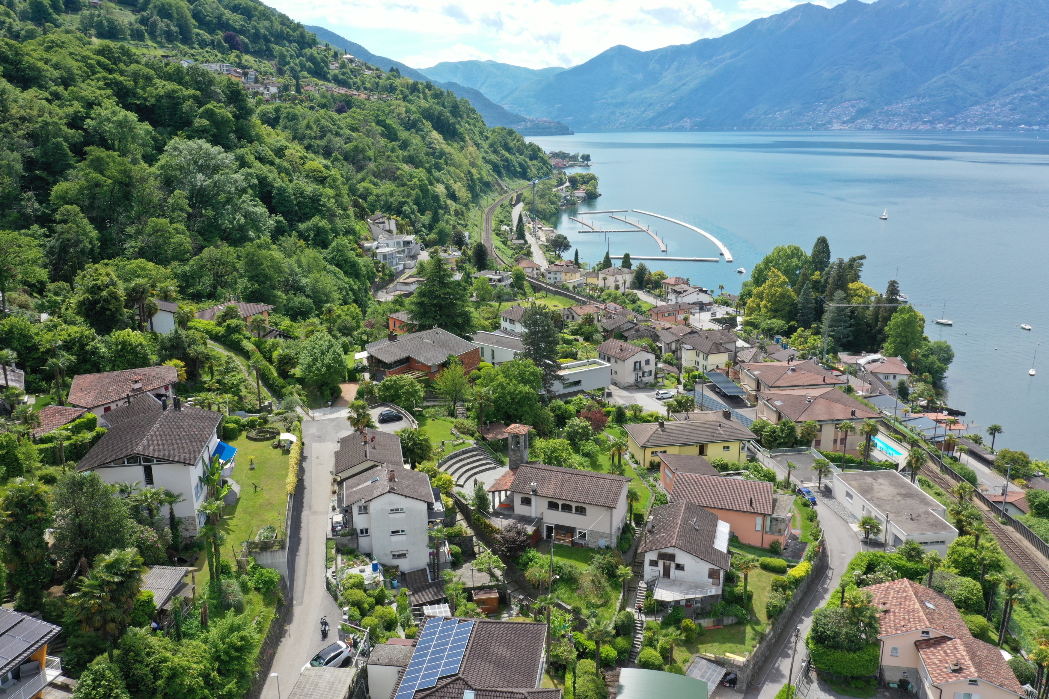 Luftaufnahme einer grünen Hanglage am See