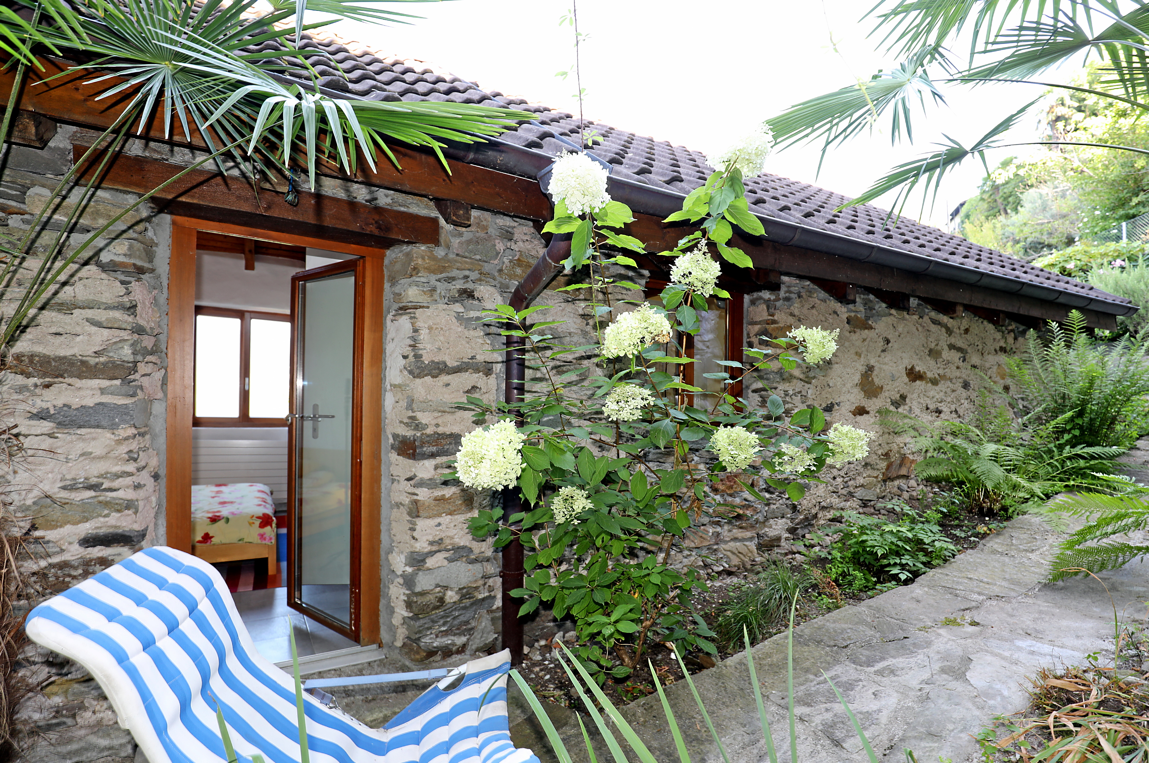 Steinhaus mit Garten und offener Terrassentür