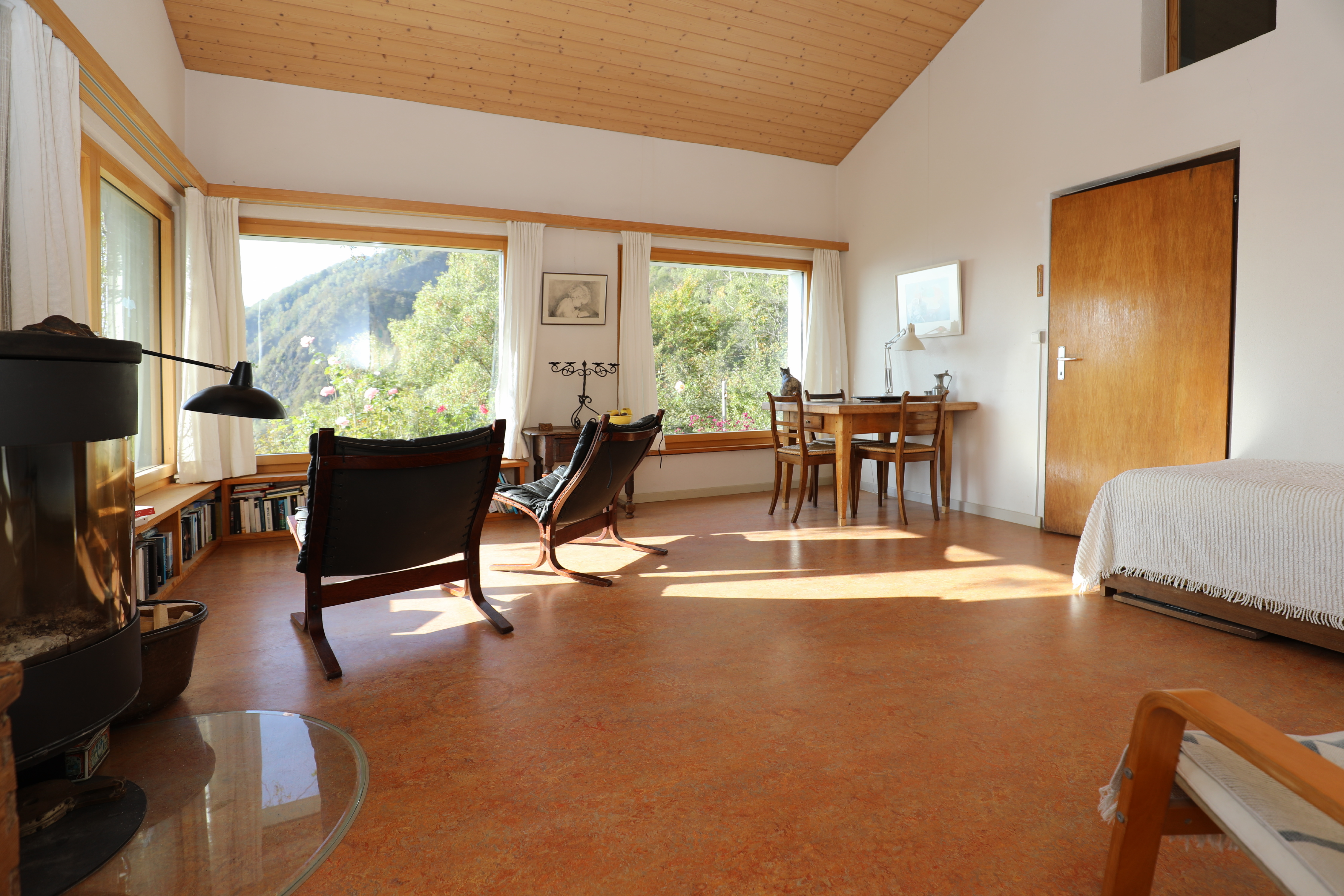 Heller Wohnraum mit großen Fenstern und Bergblick