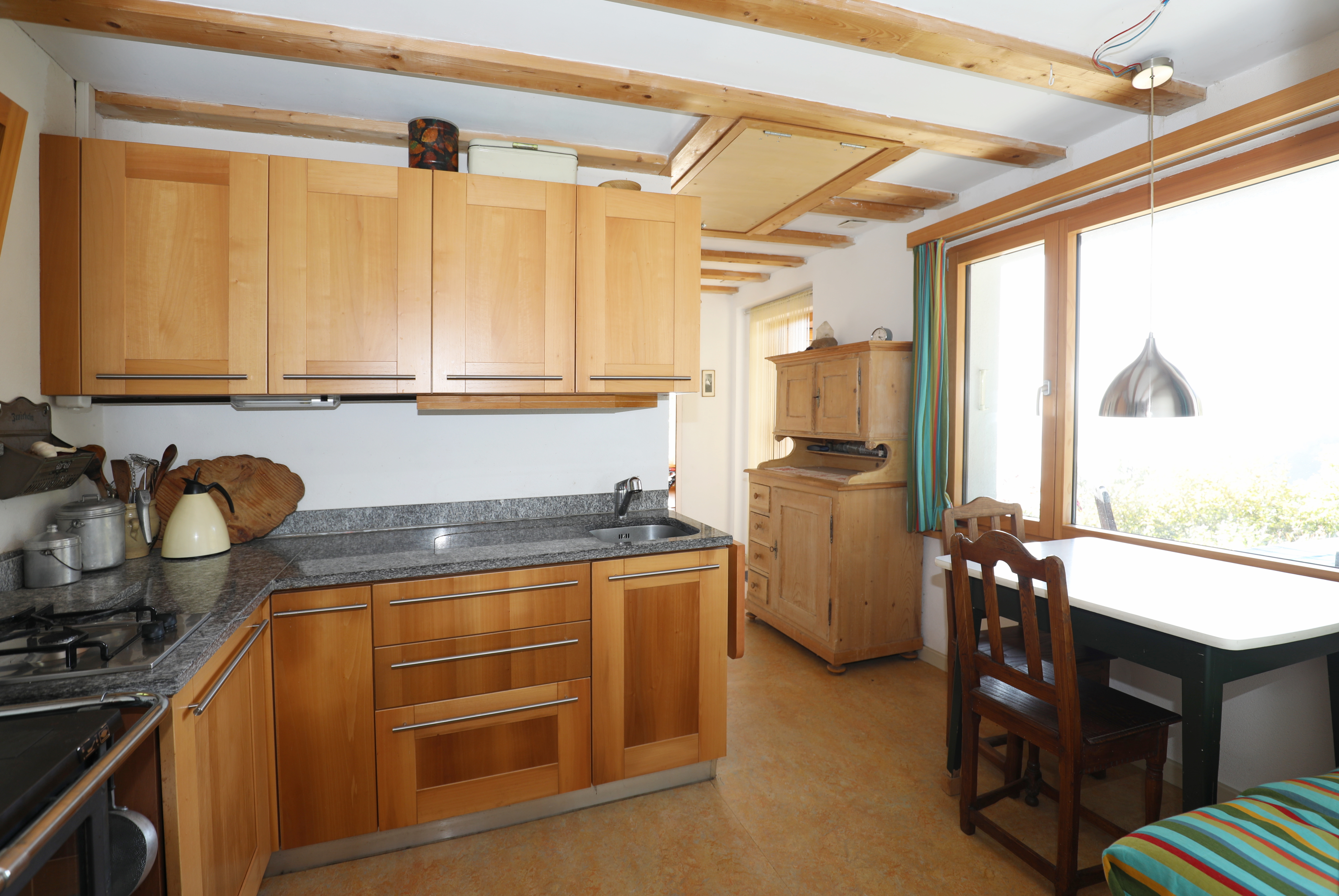 Küche mit Holzfronten und großem Fenster