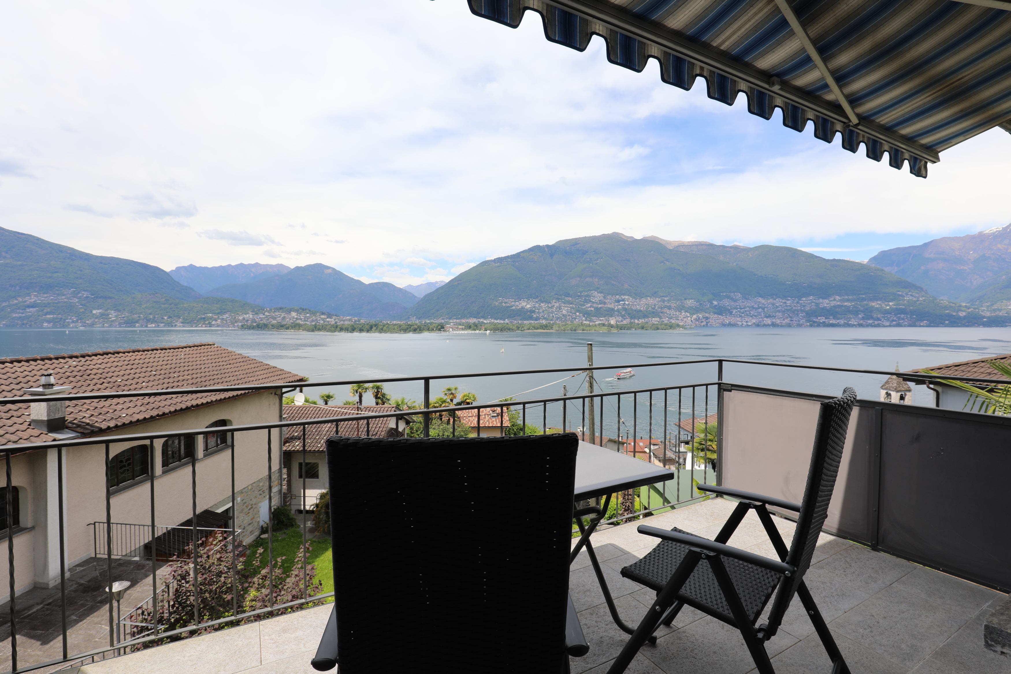 Seeblick von einem Balkon mit Sitzmöbeln