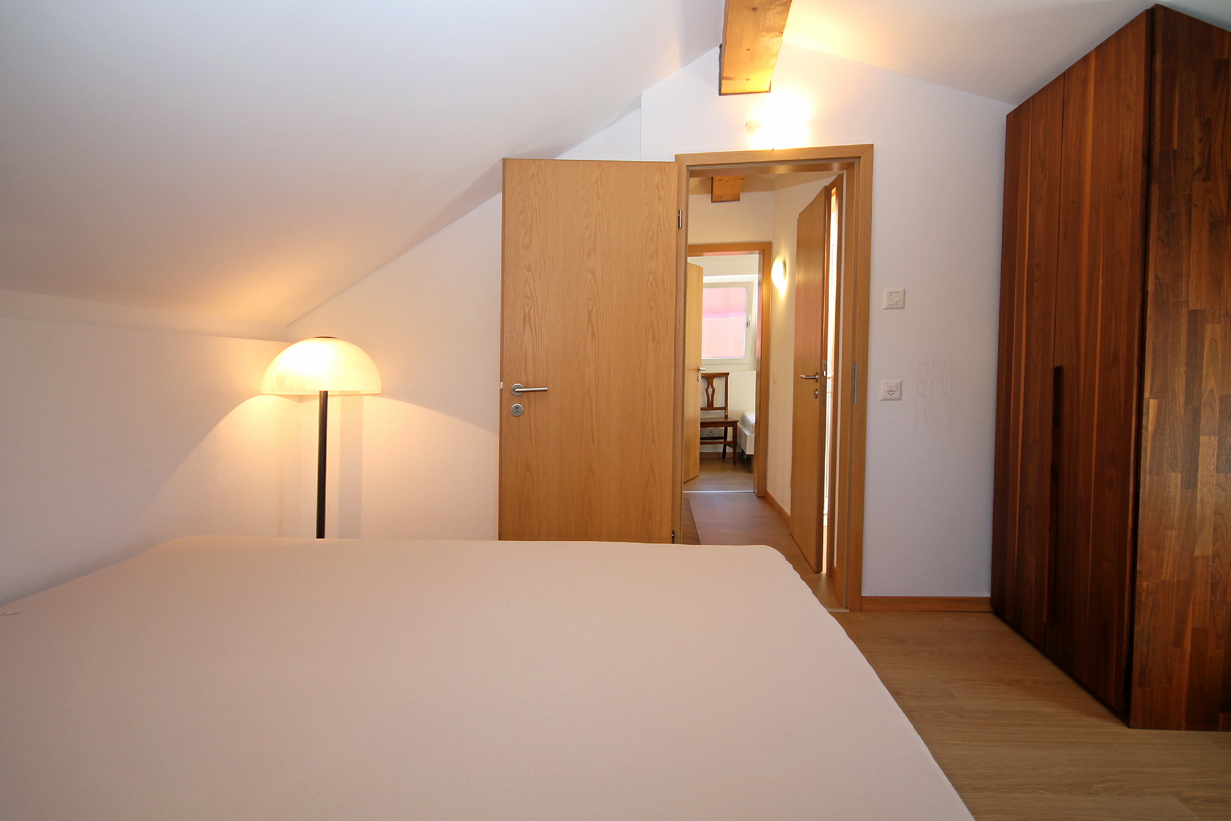 Dachzimmer mit Holzmöbeln und Schrägen