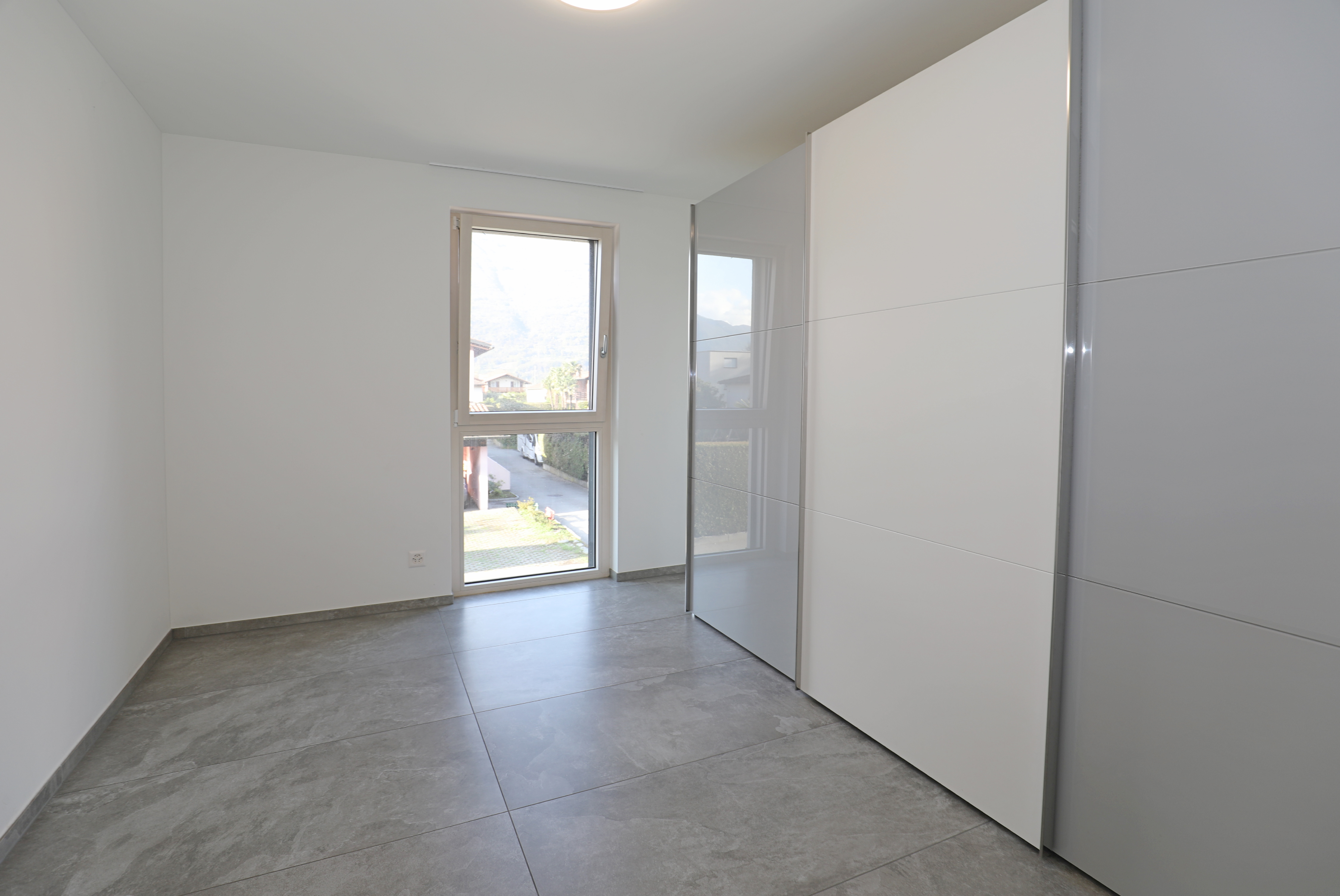 Moderne, helle Innenaufnahme mit großem Fenster und Einbauschrank