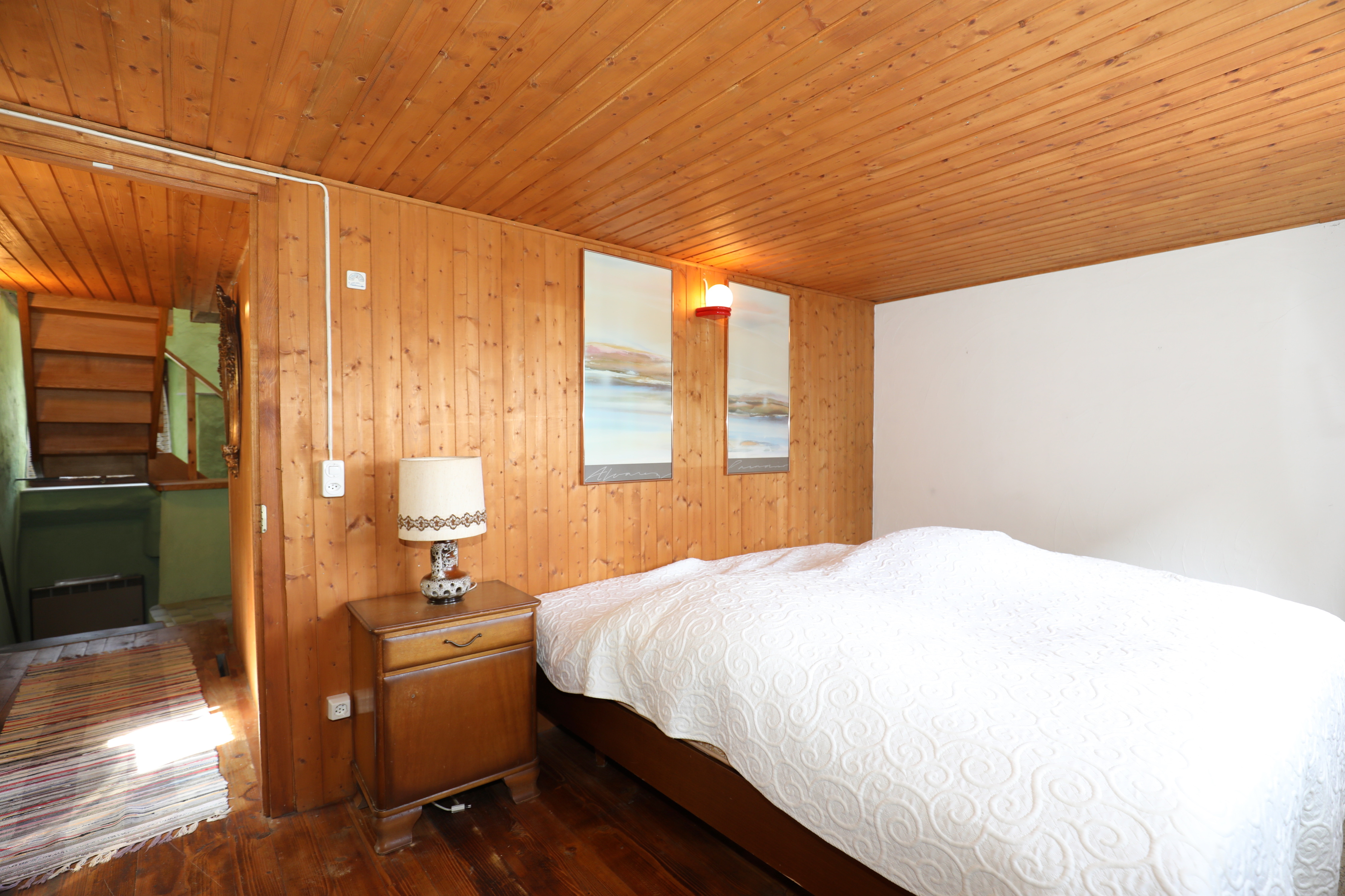 Rustikal eingerichtetes Schlafzimmer mit Holzverkleidung