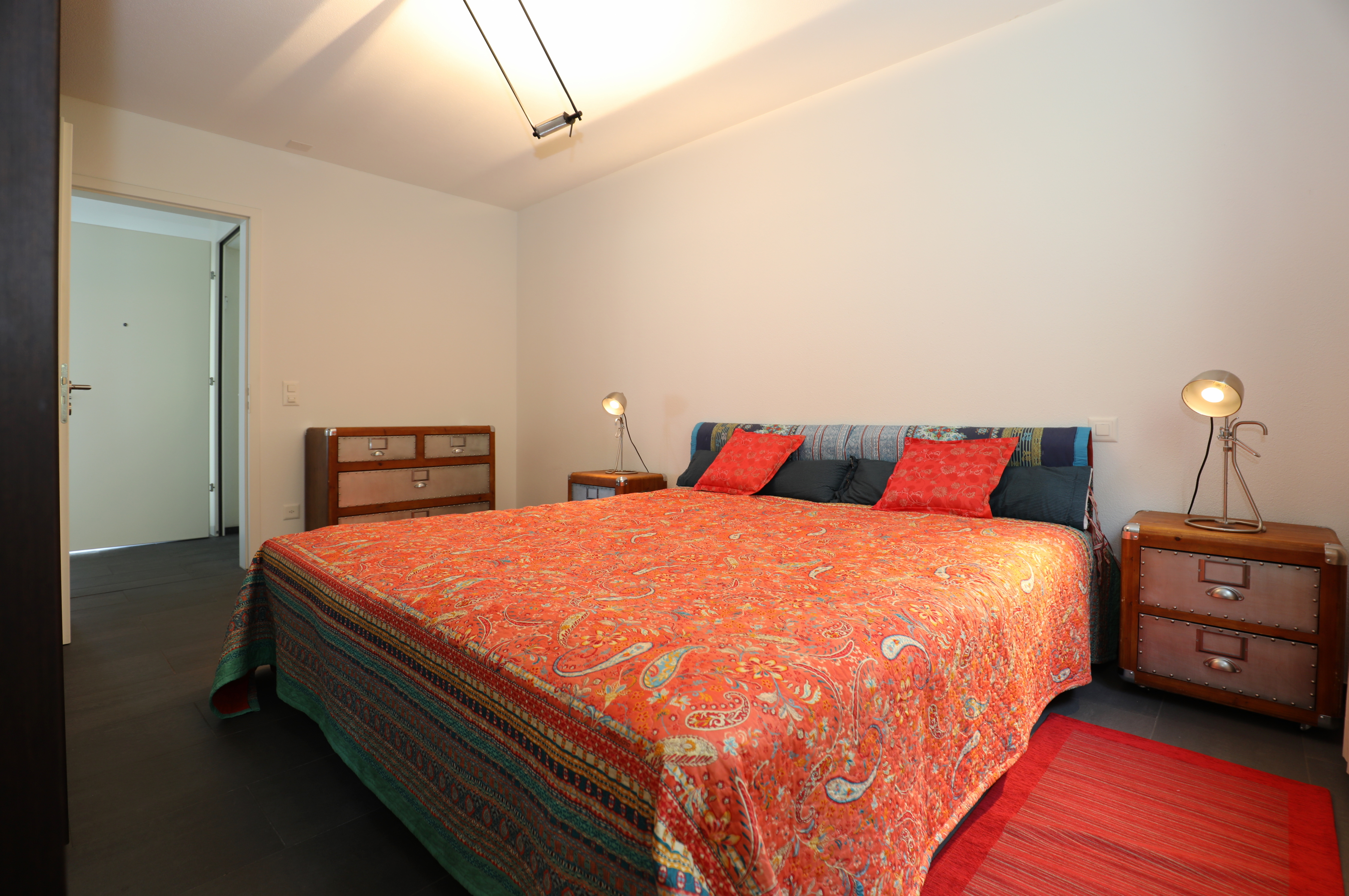 Schlafzimmer mit farbenfroher Bettwäsche