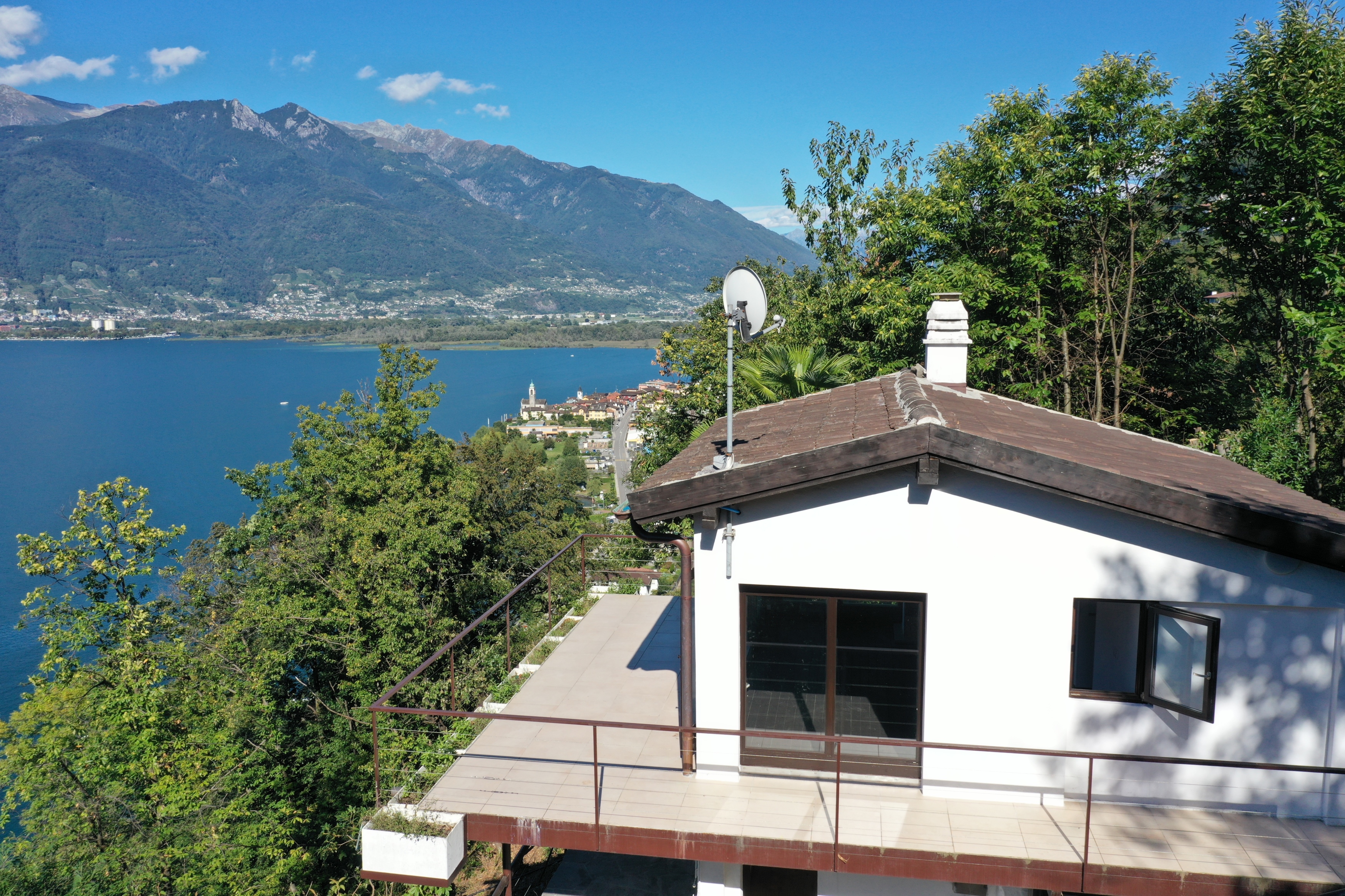 Seeblick mit Berghang und Hausdach