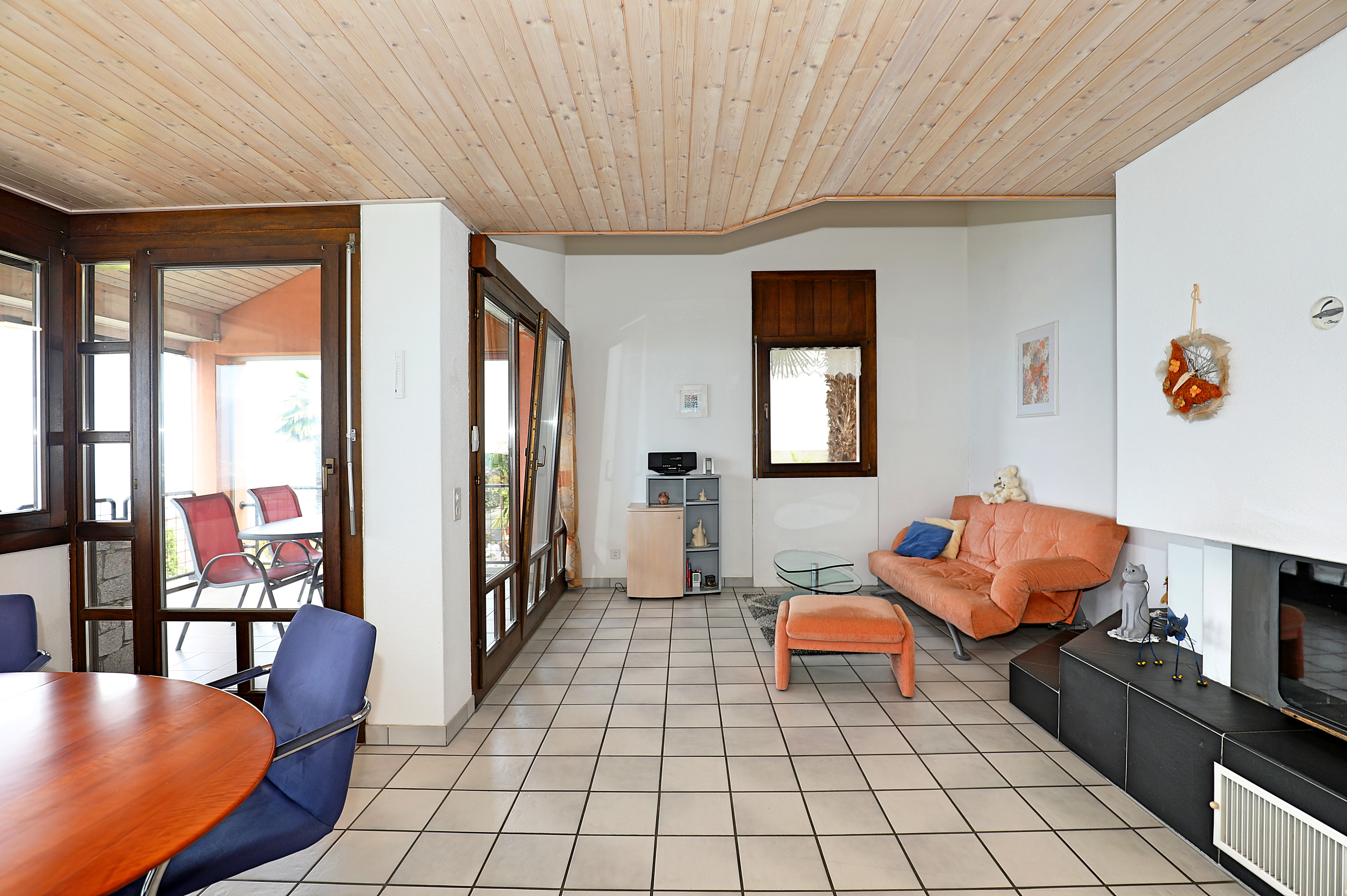 Heller Wohnraum mit Kamin und Zugang zur Terrasse