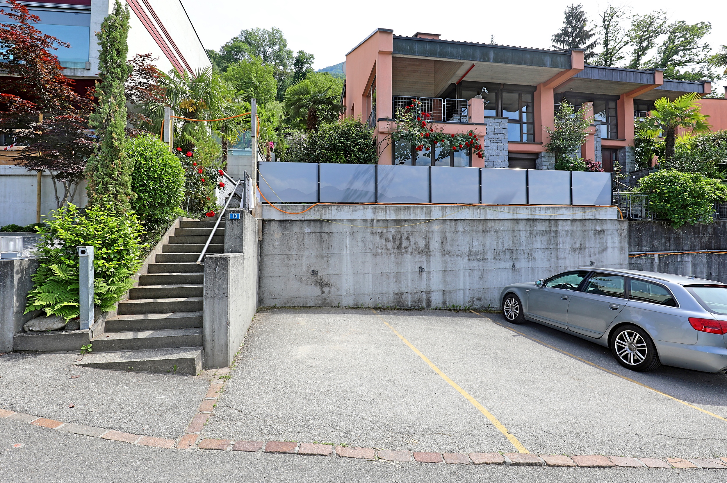 Außenansicht eines terrassierten Wohnhauses mit Zufahrt