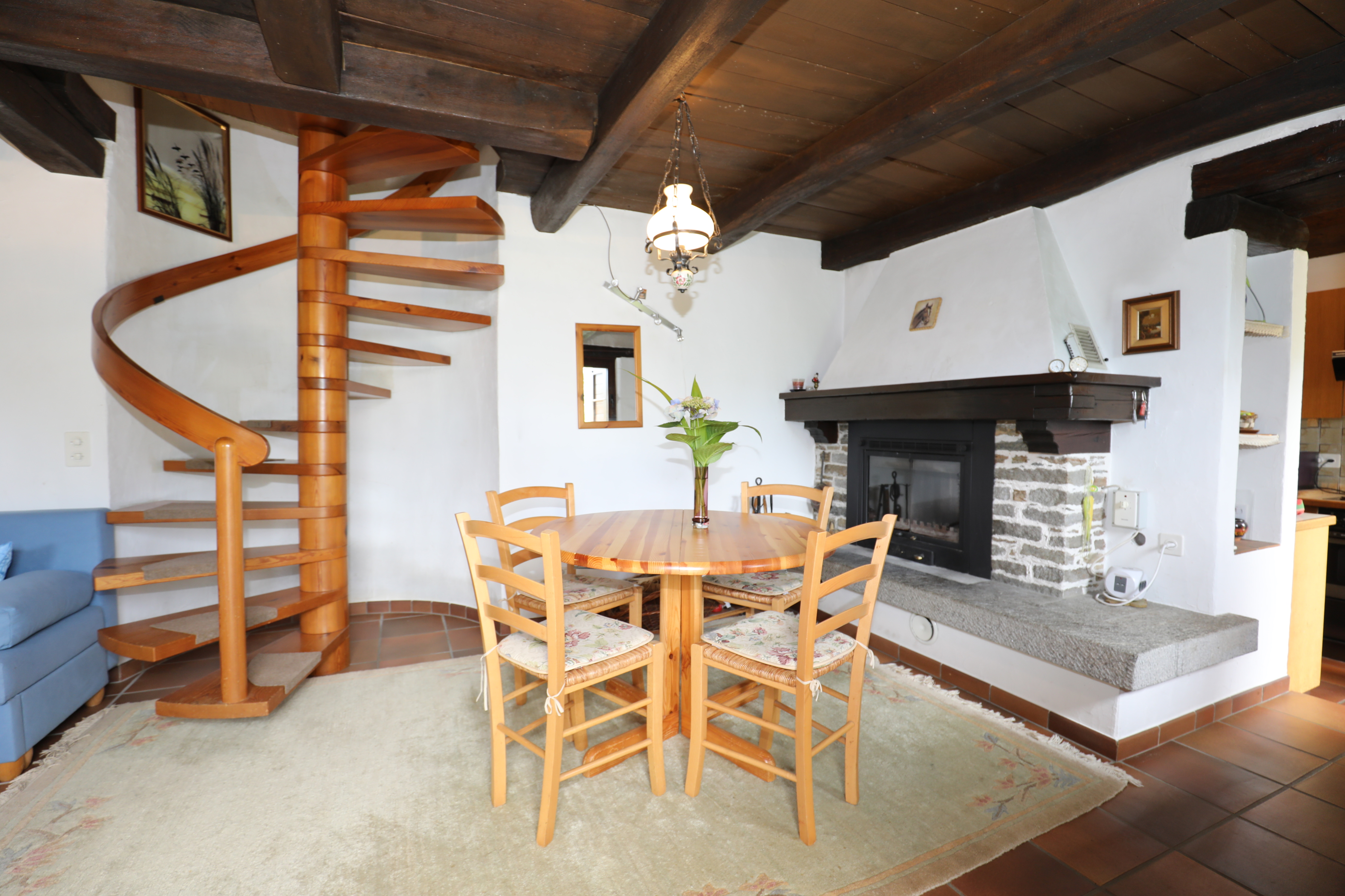Wohn- und Essbereich mit Kamin und Wendeltreppe