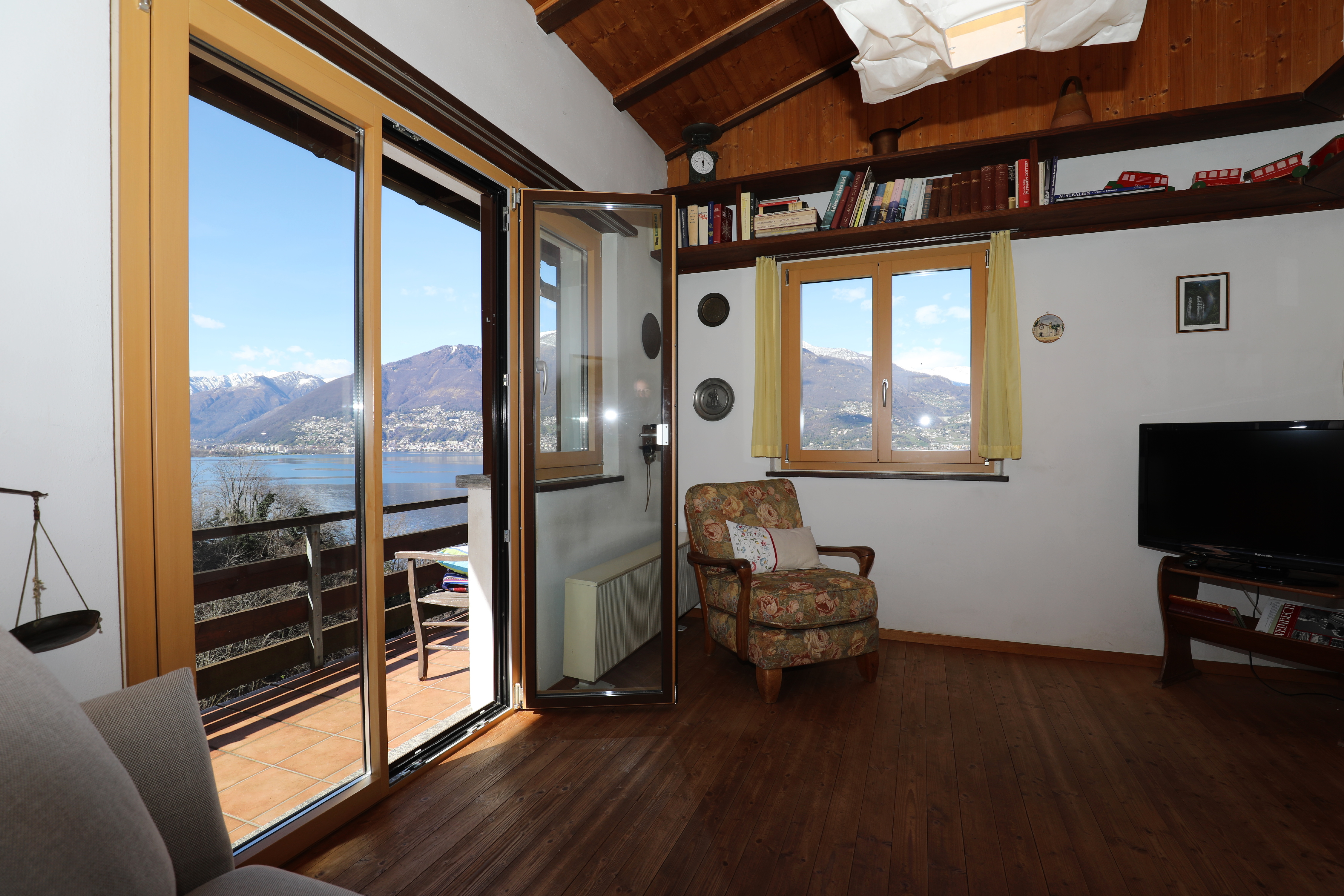 Wohnzimmer mit Balkonblick auf See und Berge