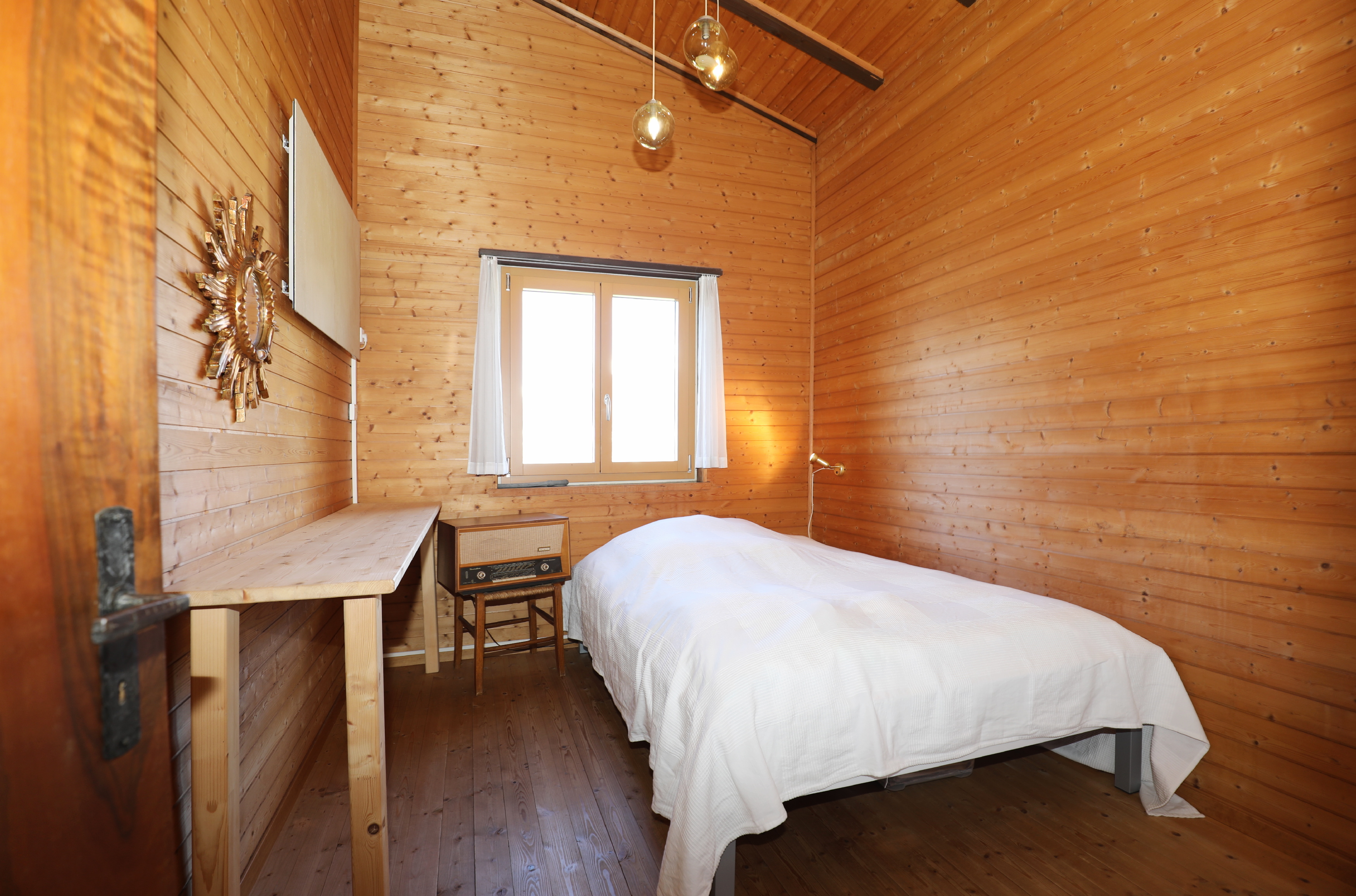 Holzverkleidetes Schlafzimmer mit Einzelbett