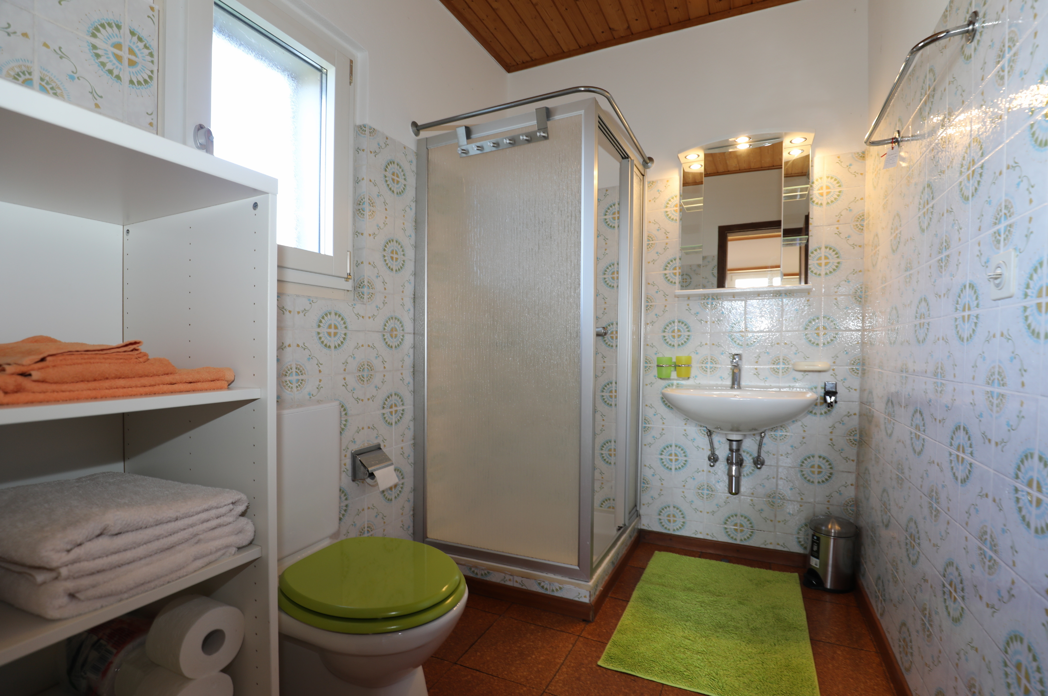 Badezimmer mit Dusche und floralem Fliesenmuster