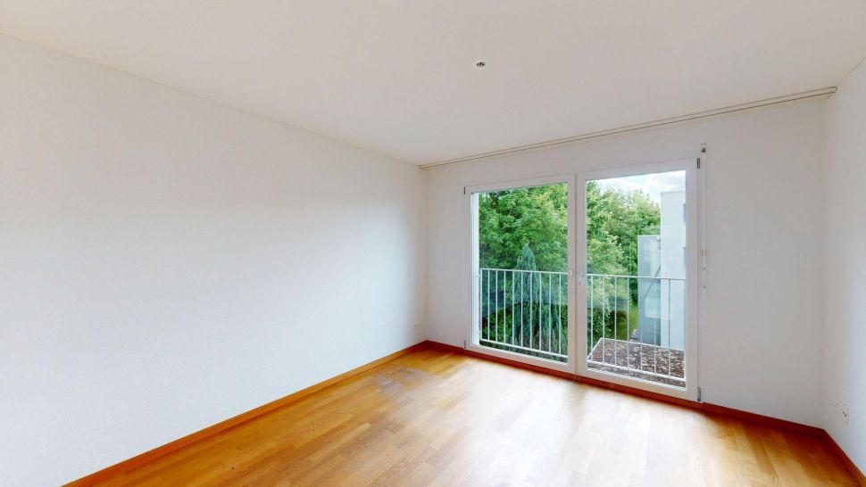 Helles, leeres Zimmer mit Balkonzugang
