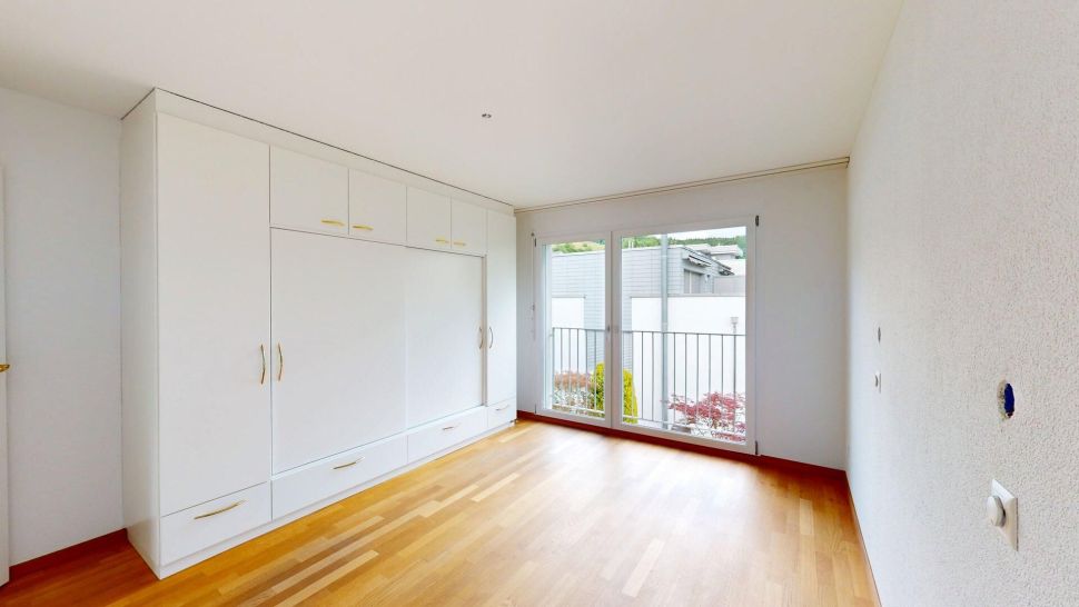 Helles Schlafzimmer mit Einbauschrank und Balkonzugang