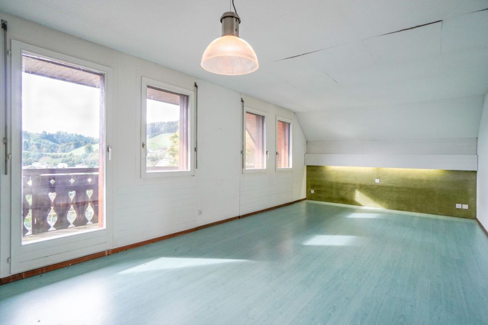 Heller Dachgeschossraum mit Balkon und vielen Fenstern