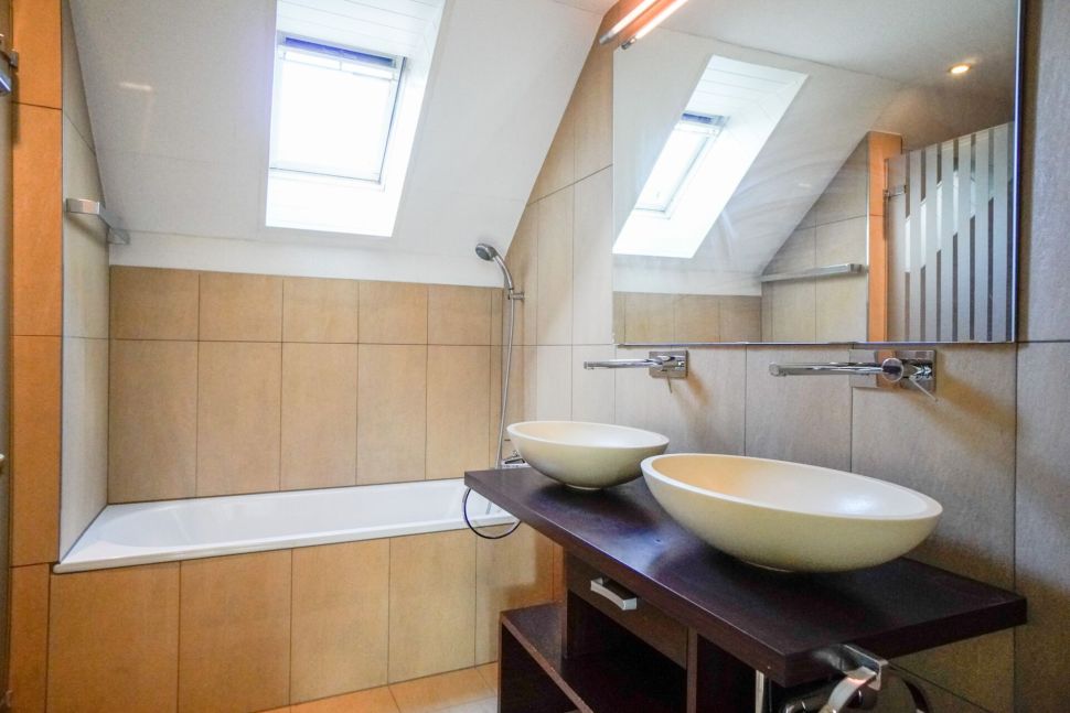Modernes Bad mit Doppelwaschbecken unter Dachfenstern
