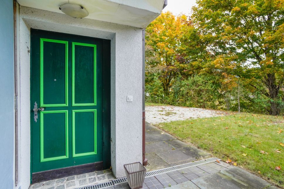 Grüne Hauseingangstür neben Gartenweg