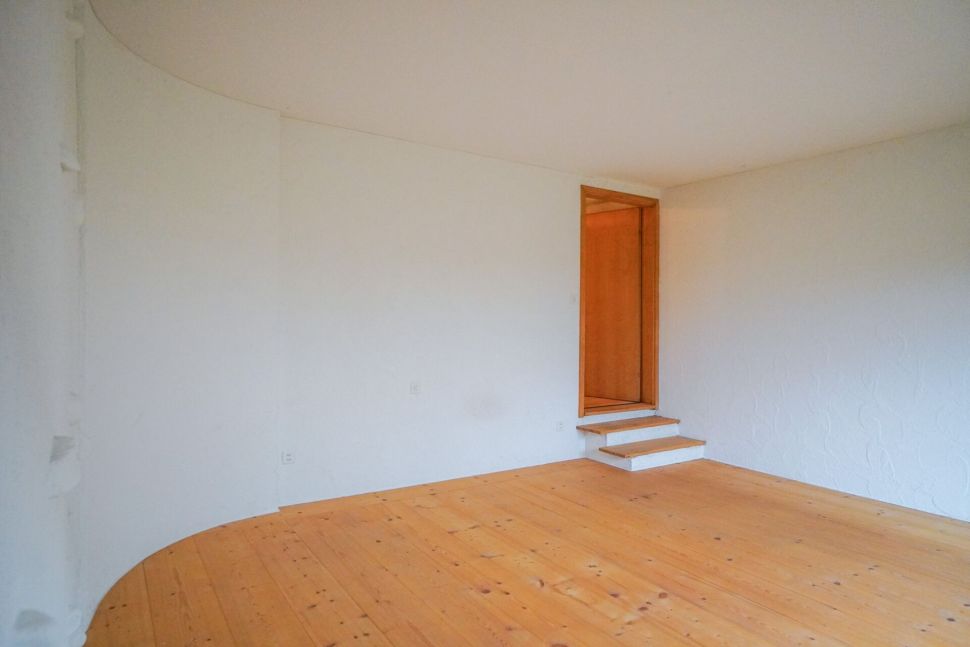 Leerer Raum mit Holzfußboden und kleiner Stufe
