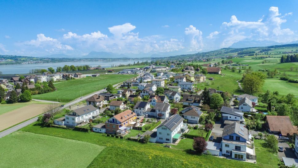Luftaufnahme einer ländlichen Wohnsiedlung am See